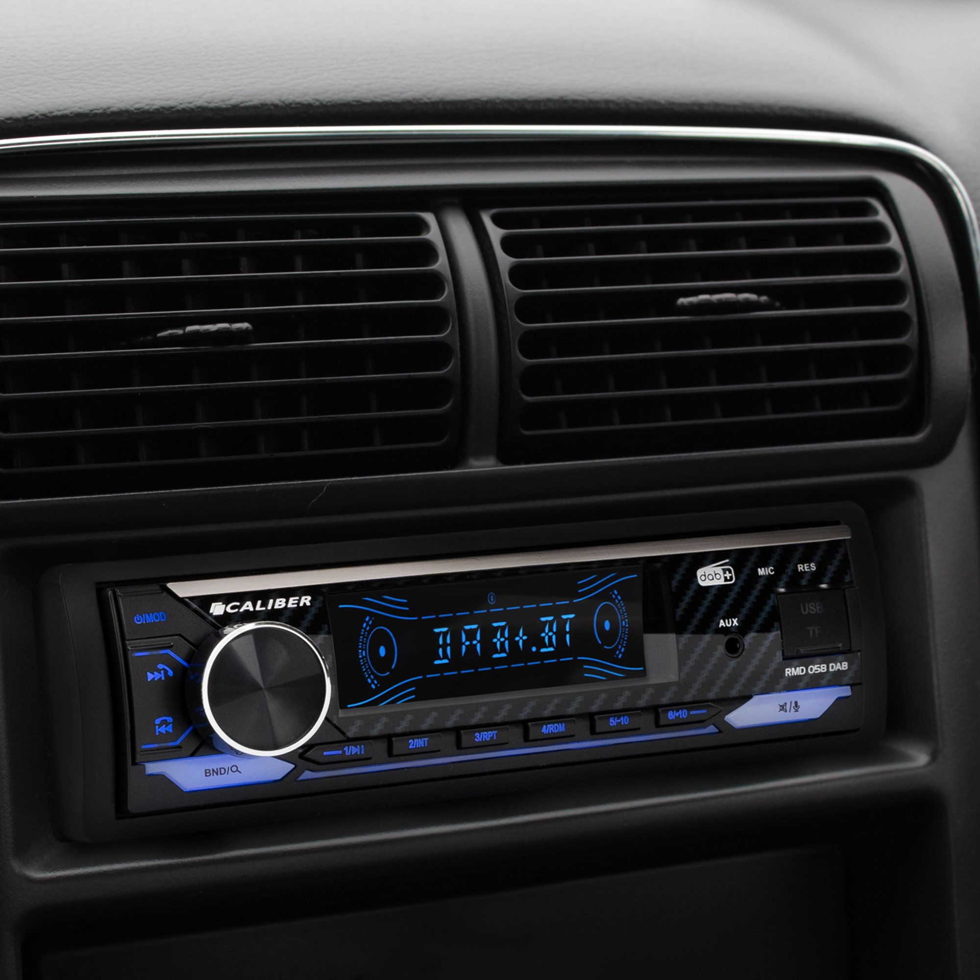 Autoradio, schwarz mit blauem Display. Text: CALIBER. Tasten für verschiedene Funktionen. Inneneinstellung.