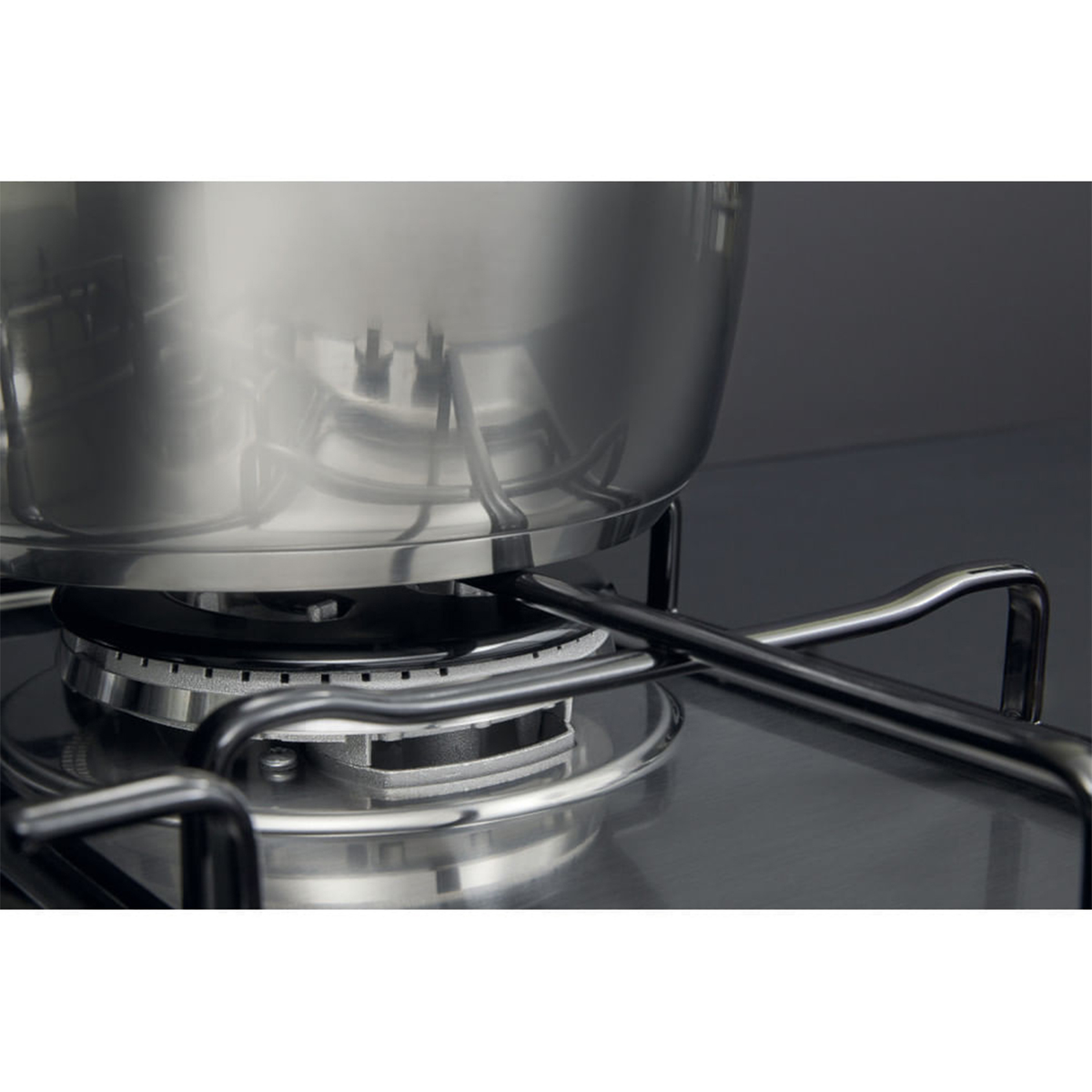 Garnek ze stali nierdzewnej na kuchence gazowej, z palnikiem i widocznymi srebrnymi detalami.