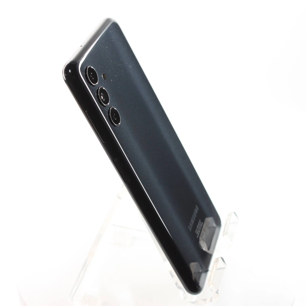 Smartphone nero su supporto, angolato. Tre fotocamere posteriori visibili. Sfondo bianco.