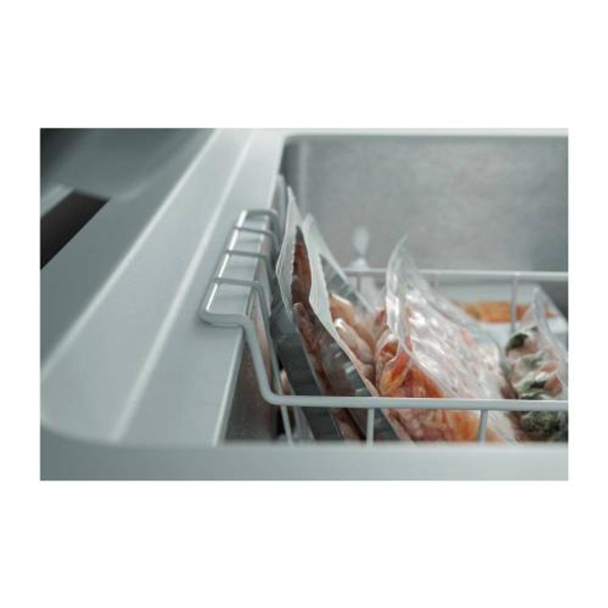 Primer plano de paquetes de alimentos congelados en una cesta del congelador.