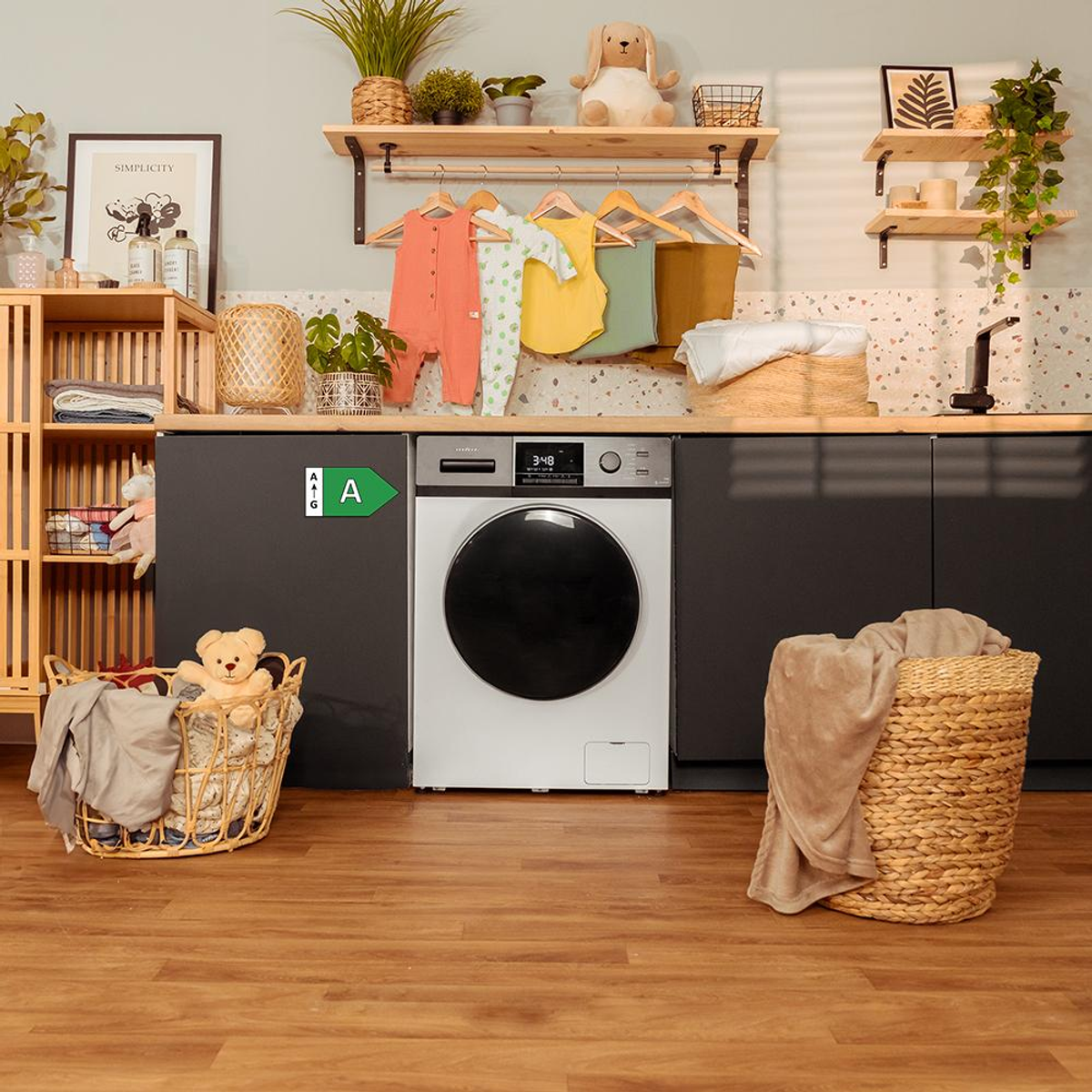 Lavanderia con lavatrice, cesti per la biancheria e vestiti per bambini appesi.