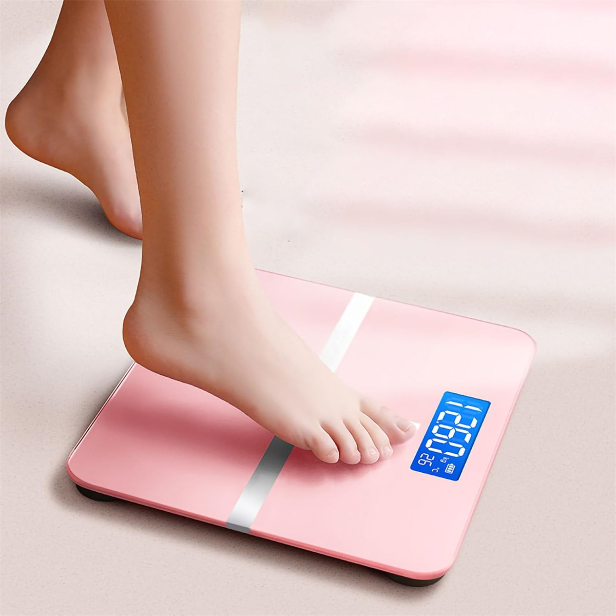 Eine rosa Digitalwaage mit einem Fuß darauf. Die Anzeige zeigt 120,8 kg.