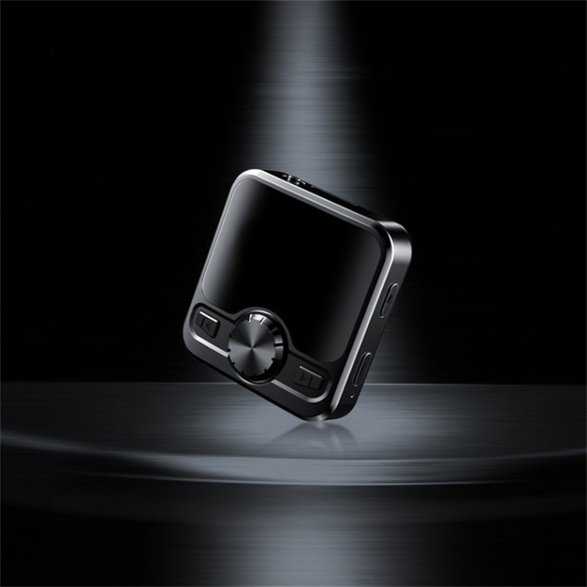 Schwarzes, quadratisches Gerät auf reflektierender Oberfläche. Dunkler, beleuchteter Hintergrund.