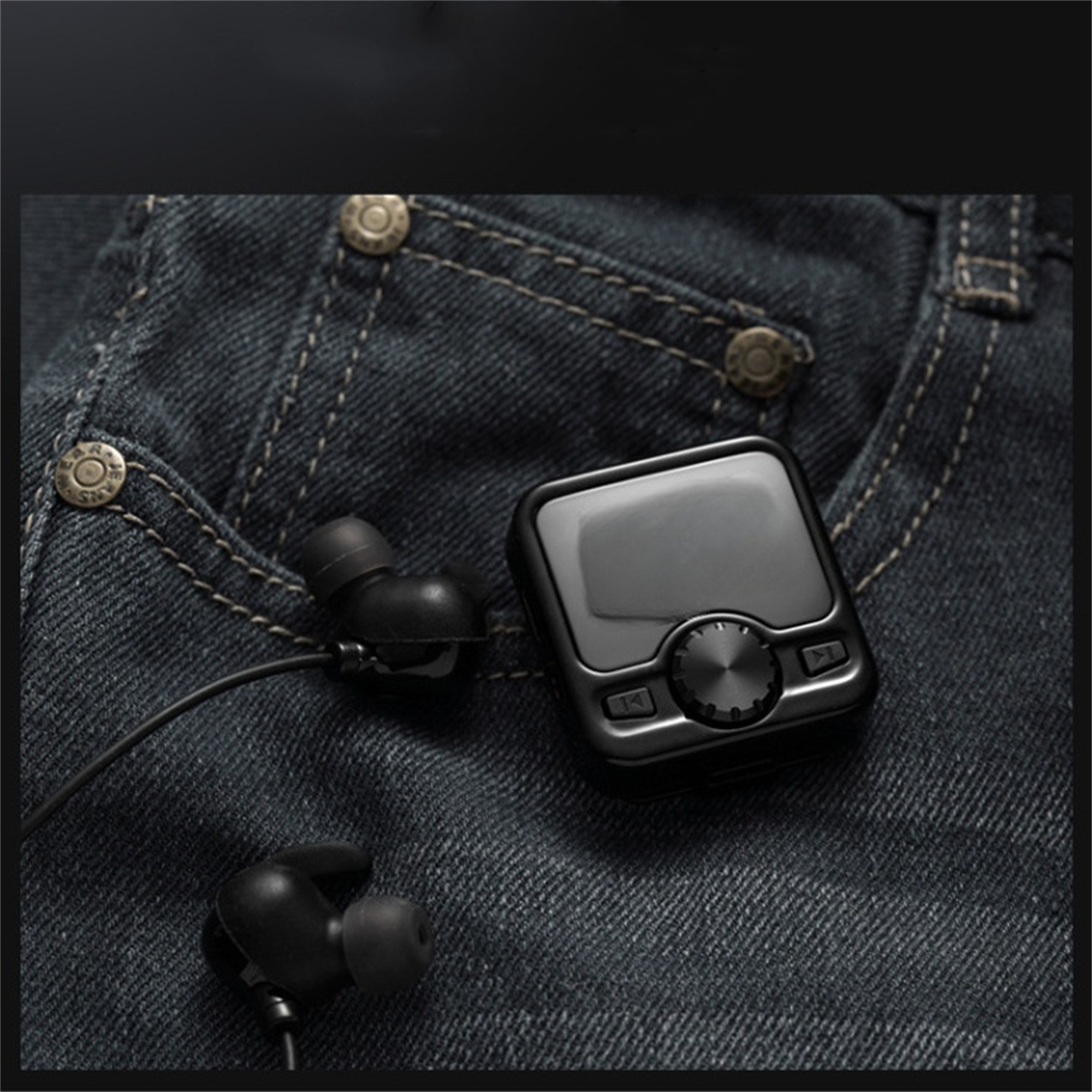 Schwarze Ohrhörer und ein schwarzer MP3-Player in einer Jeans-Tasche. Knöpfe am Player sind sichtbar.
