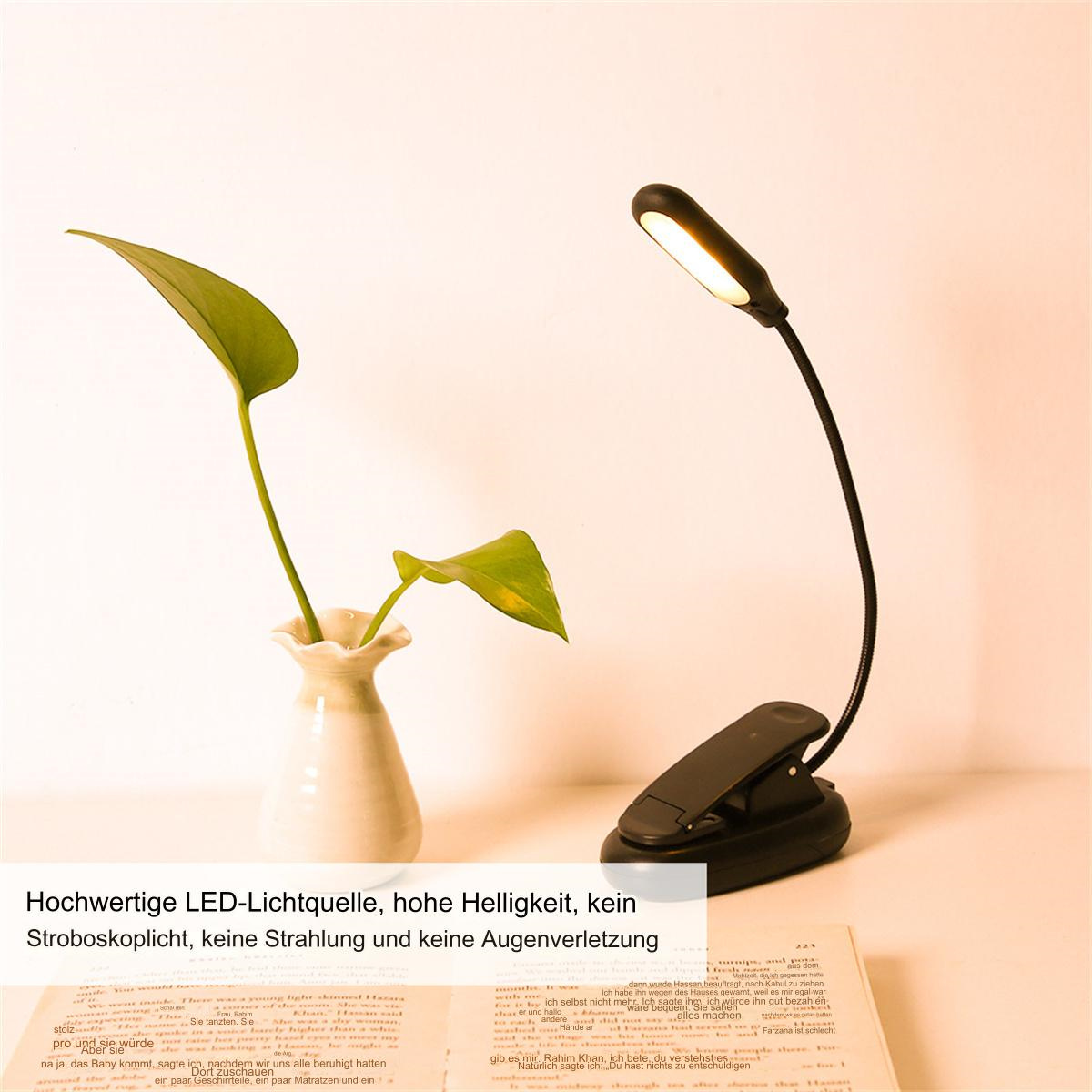 Clip-on LED-Leselampe mit Pflanze in Vase und Buch. Lampe auf Buch, Pflanze in Vase.