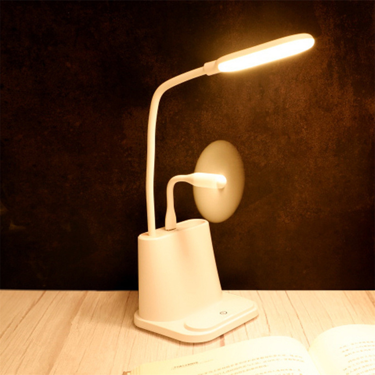 Eine weiße Schreibtischlampe mit flexiblem Hals und Ladebasis. Sie steht auf einem Holztisch.