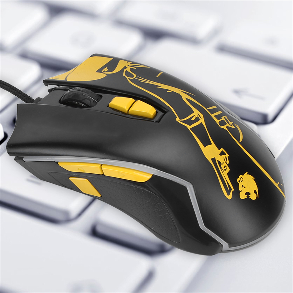 Schwarze Maus mit gelben Knöpfen und Design, auf einer weißen Tastatur.
