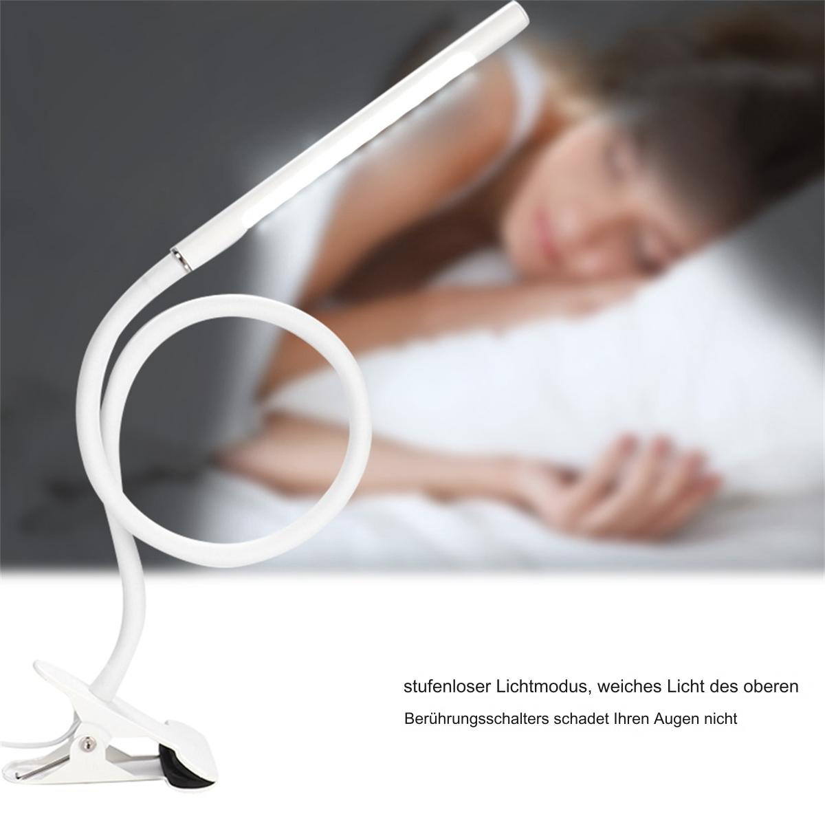 Eine weiße, flexible LED-Lampe mit schlafender Person im Hintergrund.