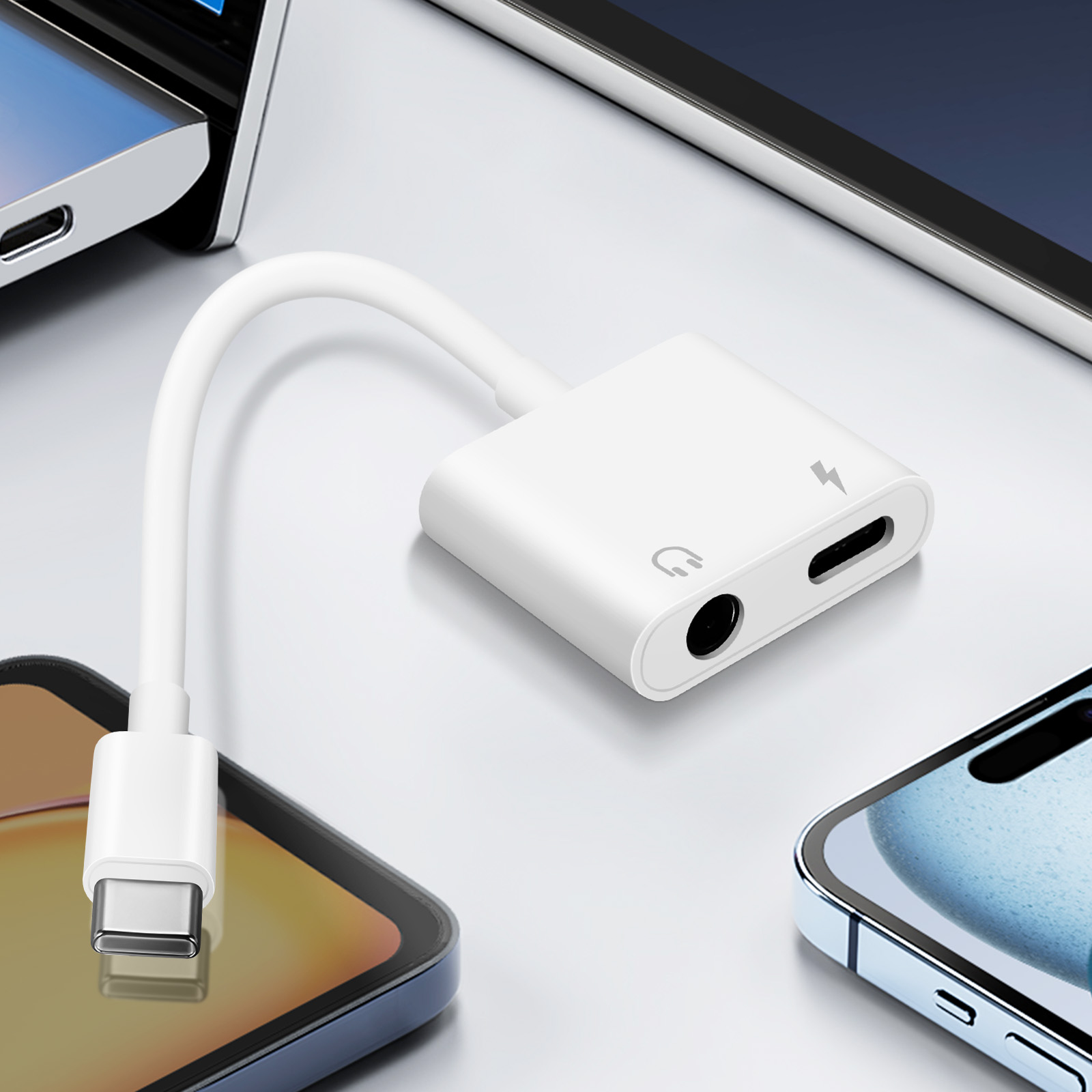 Adattatore bianco con USB-C e porte audio/ricarica. Telefoni sullo sfondo.