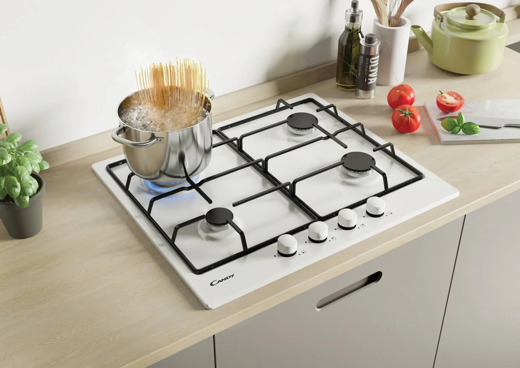 Płyta indukcyjna ze stali nierdzewnej z patelnią z gotującym się jedzeniem. Na blacie są też pomidory.