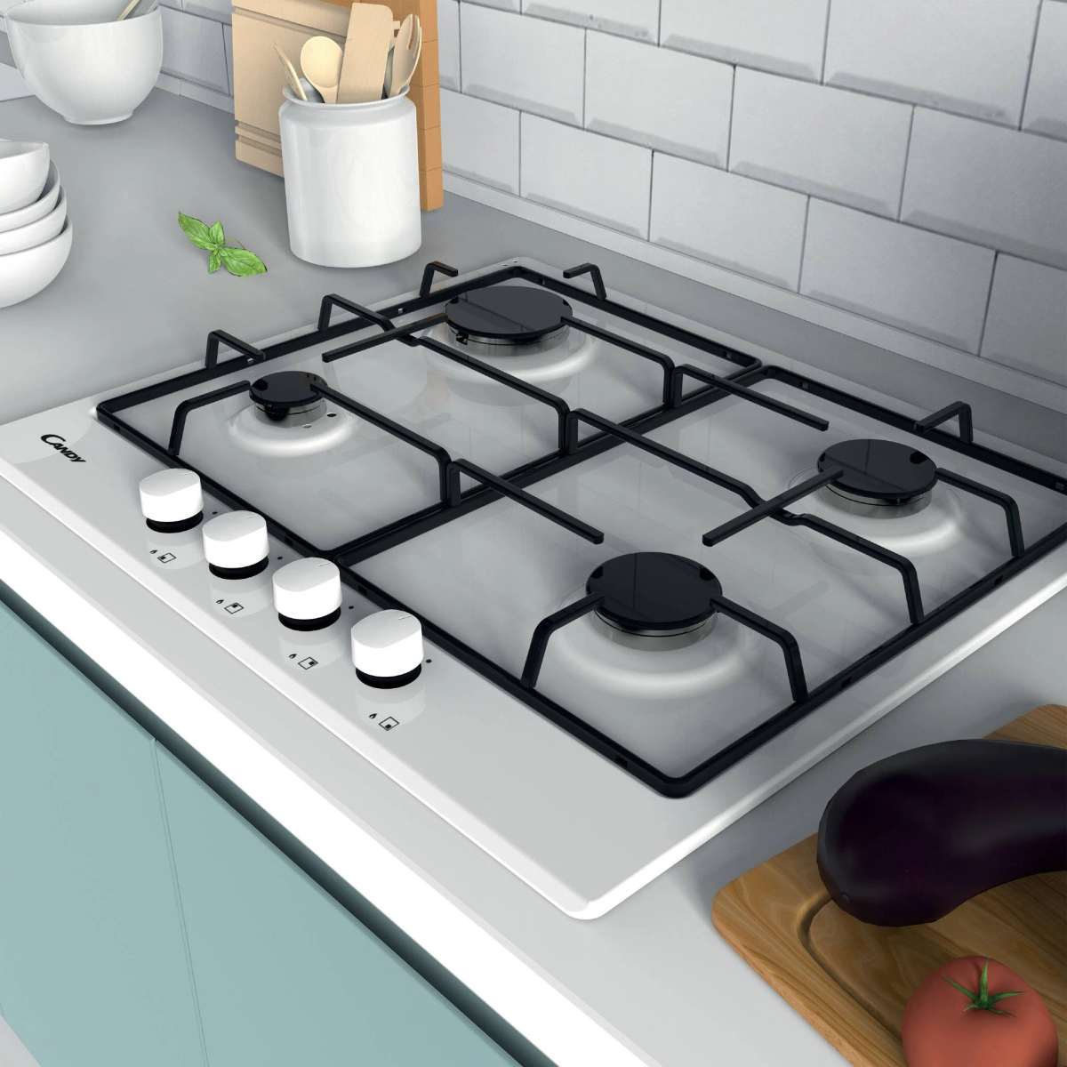 Biała kuchenka gazowa z czterema palnikami i pokrętłami, z warzywami i przyborami na blacie.