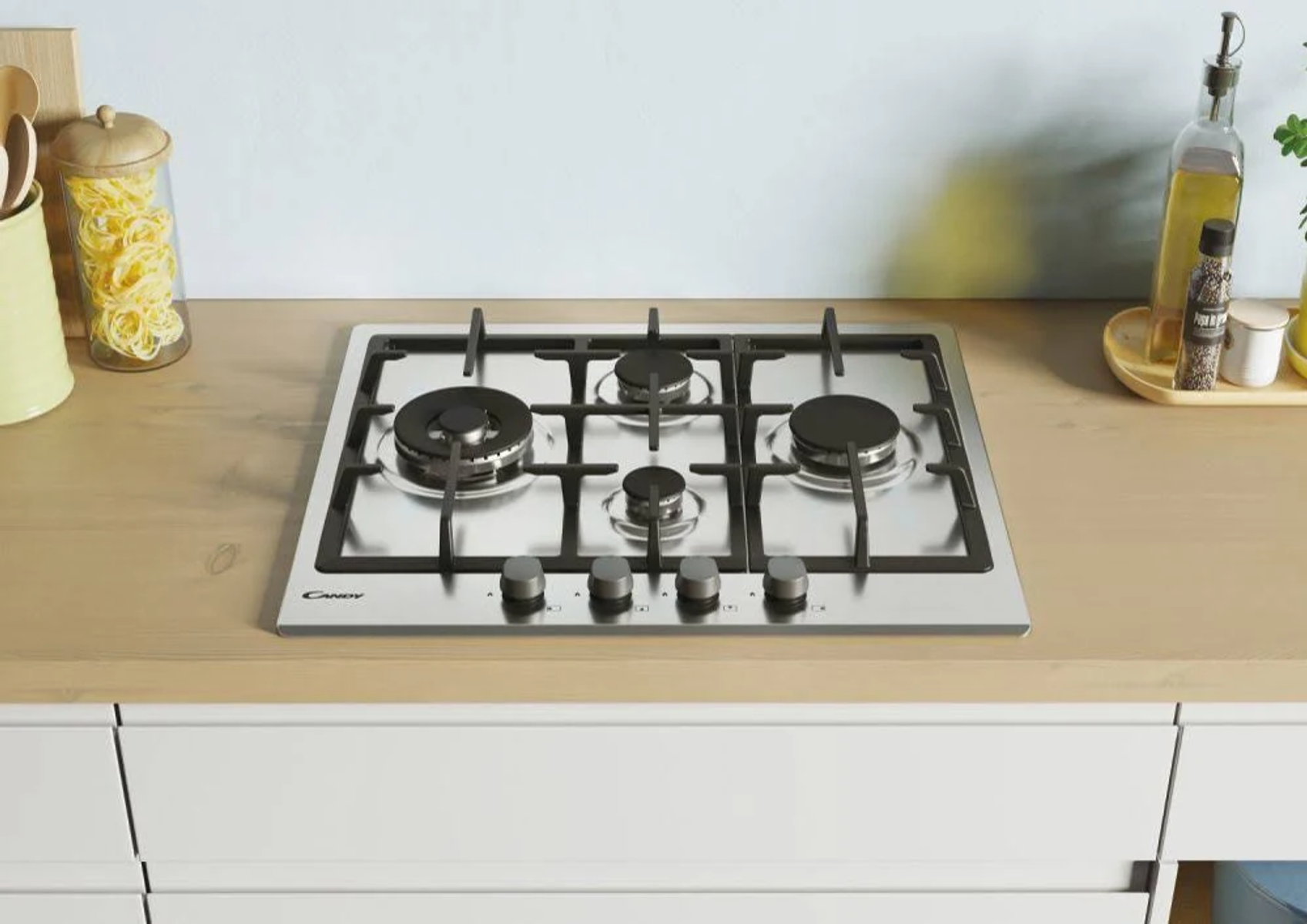 Płyta gazowa ze stali nierdzewnej z czterema palnikami, na drewnianym blacie.