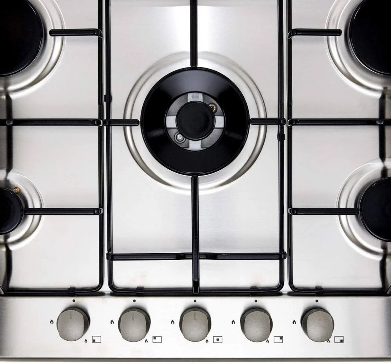 Zbliżenie na stalową płytę gazową z 5 palnikami i czarnymi kratkami.