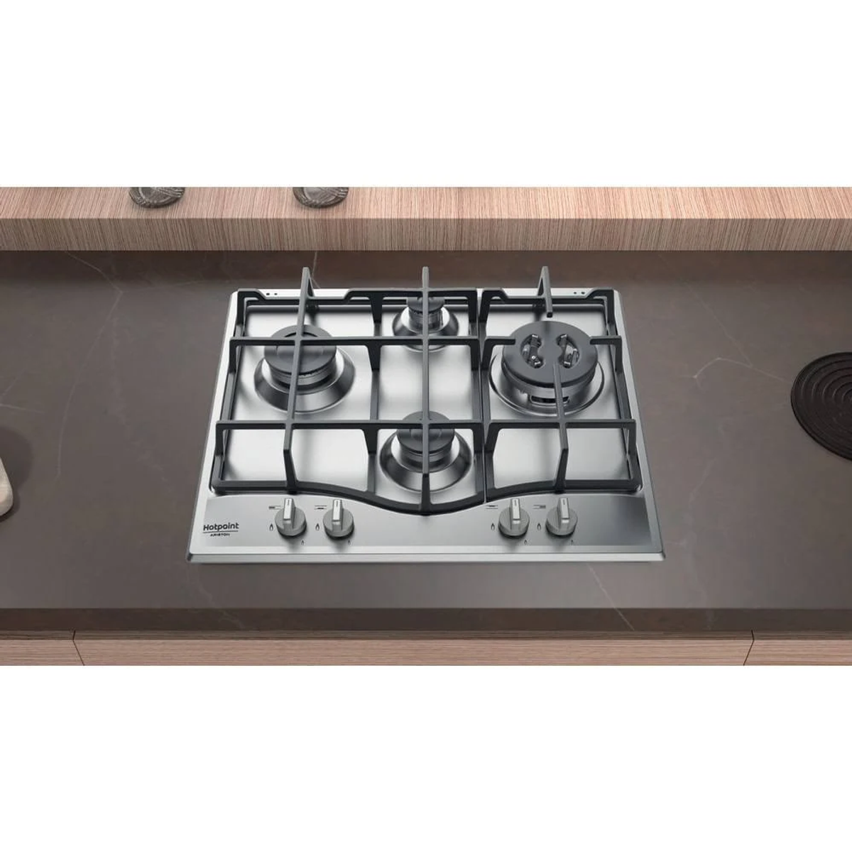 Zbliżenie czarnej kuchenki gazowej z palnikami i pokrętłami, na ciemnym blacie.