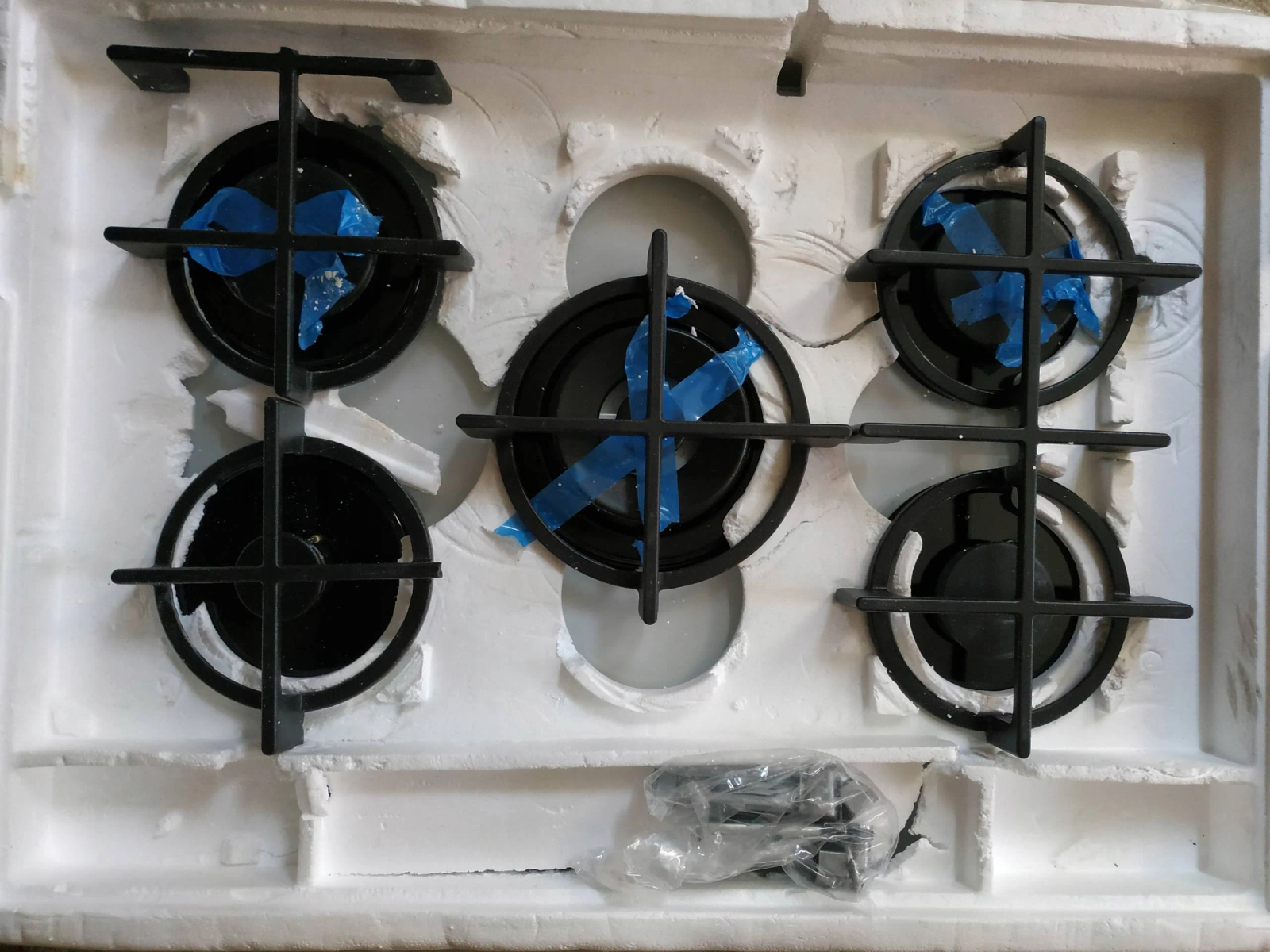 Płyta gazowa, jeszcze w opakowaniu z palnikami zakrytymi niebieską taśmą.