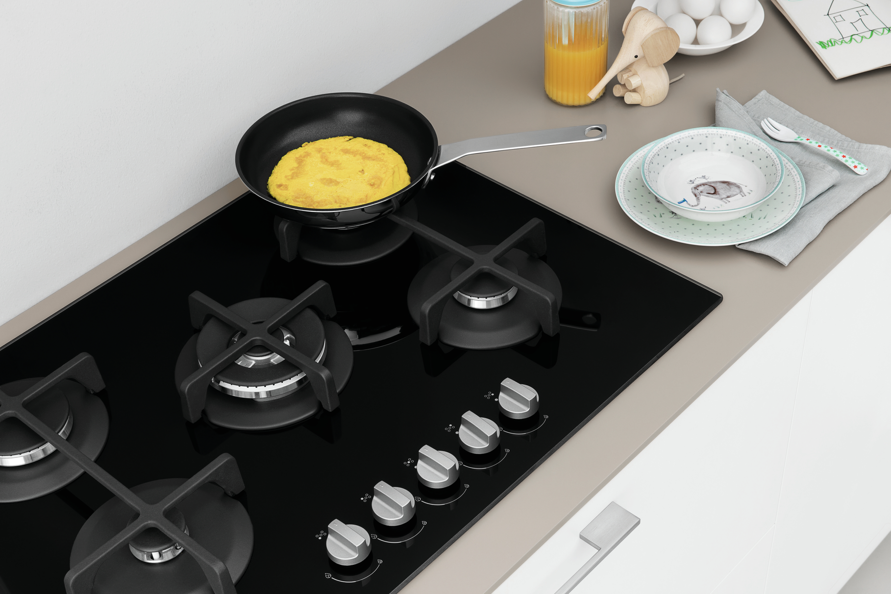 Un piano cottura nero con quattro fuochi, una padella con cibo sul fornello e articoli da cucina.
