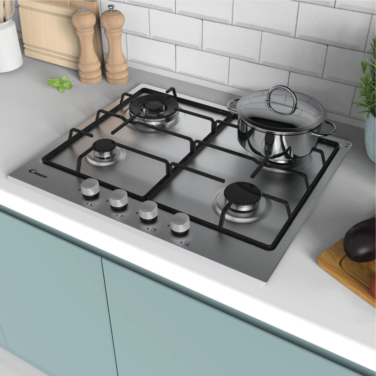 Płyta grzewcza Candy ze stali nierdzewnej z czterema palnikami. Na płycie stoi garnek. Kuchnia ma jasnoniebieską szafkę.