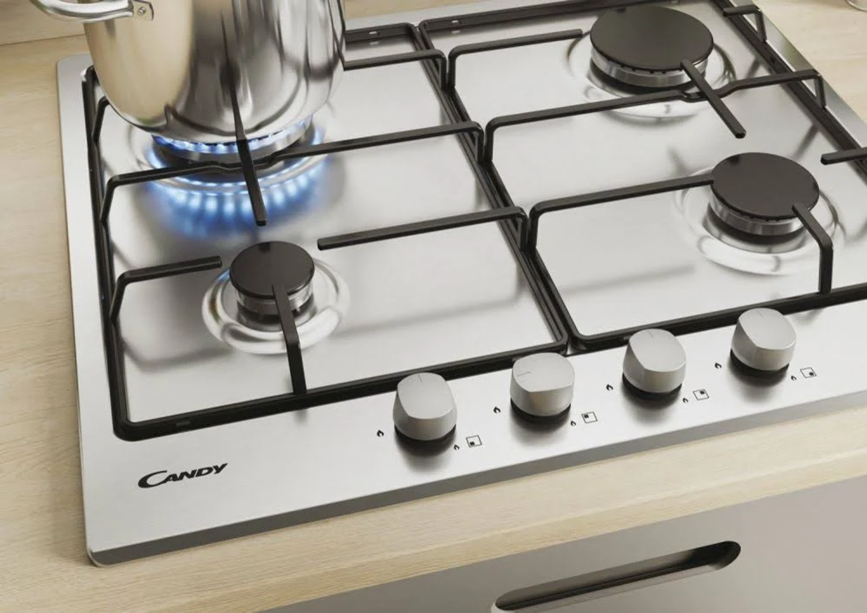 Płyta gazowa z czterema palnikami, garnkiem na ogniu i pokrętłami. Marka to 'CANDY'.