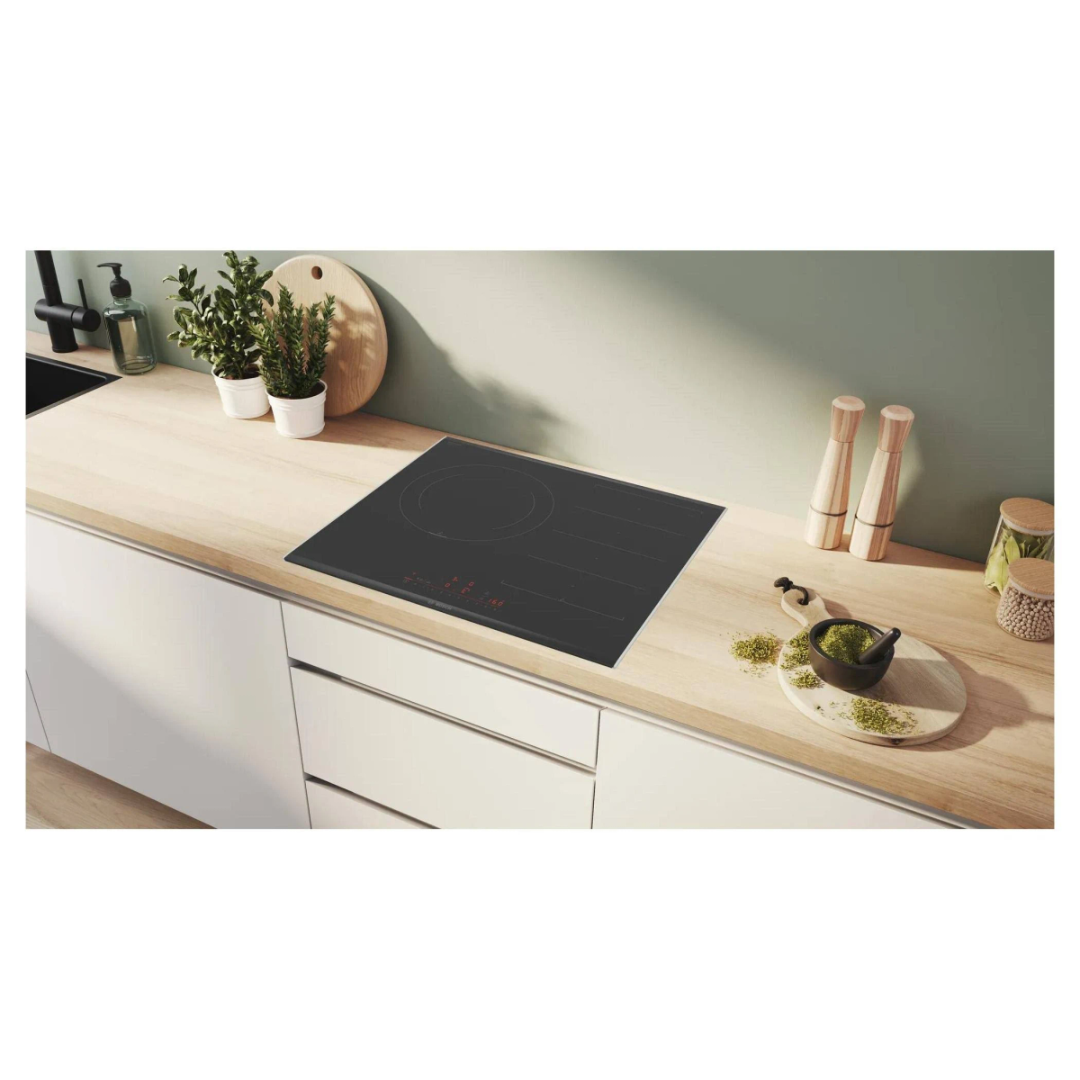 Una placa negra con un solo quemador grande, sobre una encimera de madera con decoración.