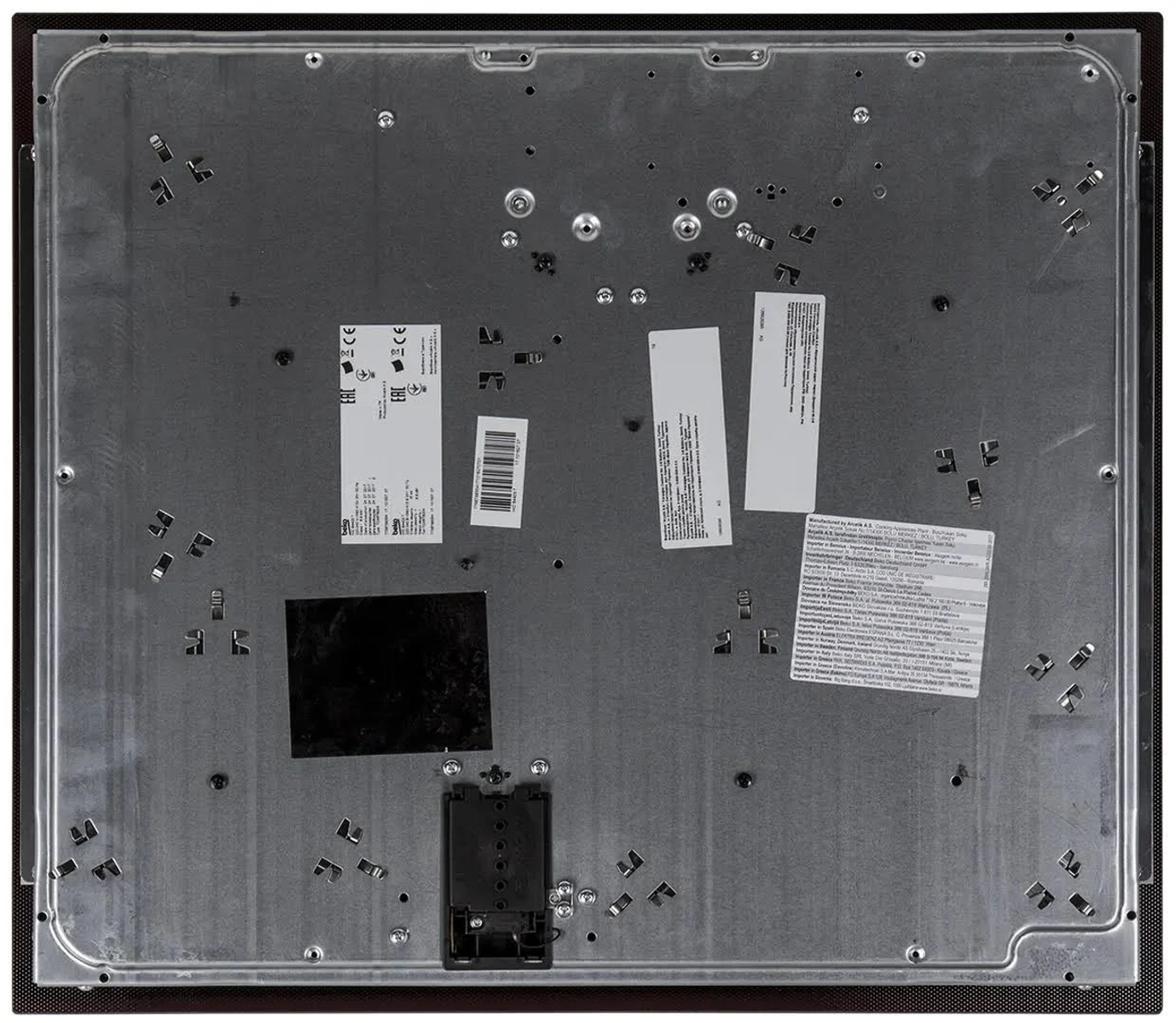 Spód płyty indukcyjnej, pokazujący elementy wewnętrzne i etykiety.