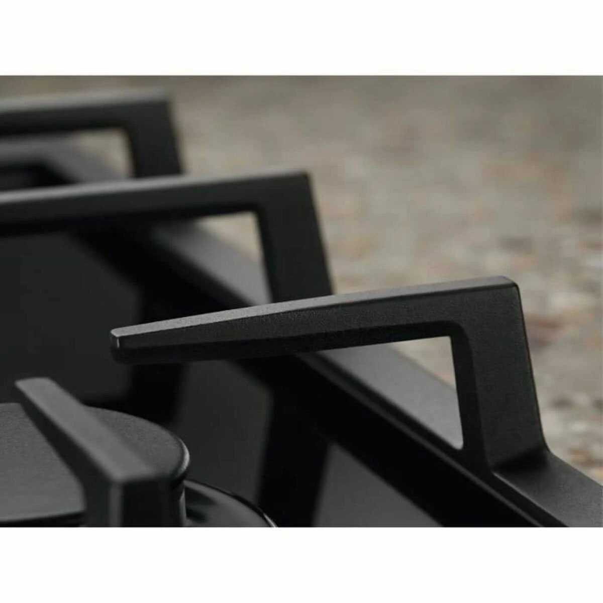 Zbliżenie pokręteł sterowania płyty gazowej. Czarny i srebrny.