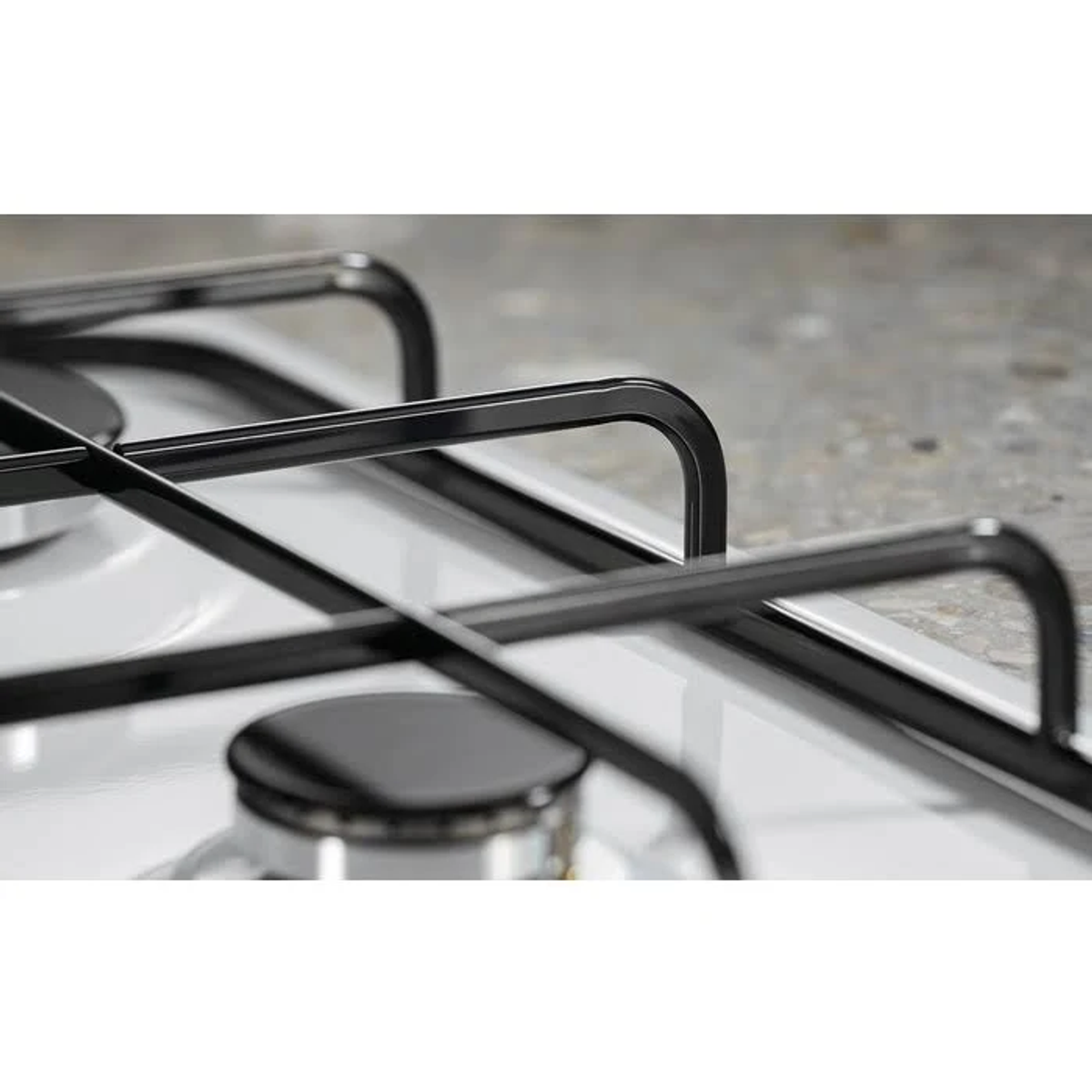Primo piano dei supporti dei bruciatori su un piano cottura bianco.
