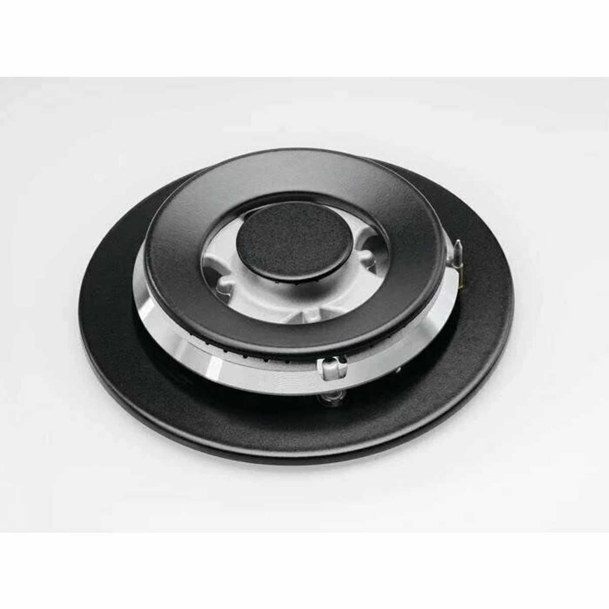 Zbliżenie palnika gazowego z czarną nasadką, srebrnym pierścieniem i czarną podstawą.