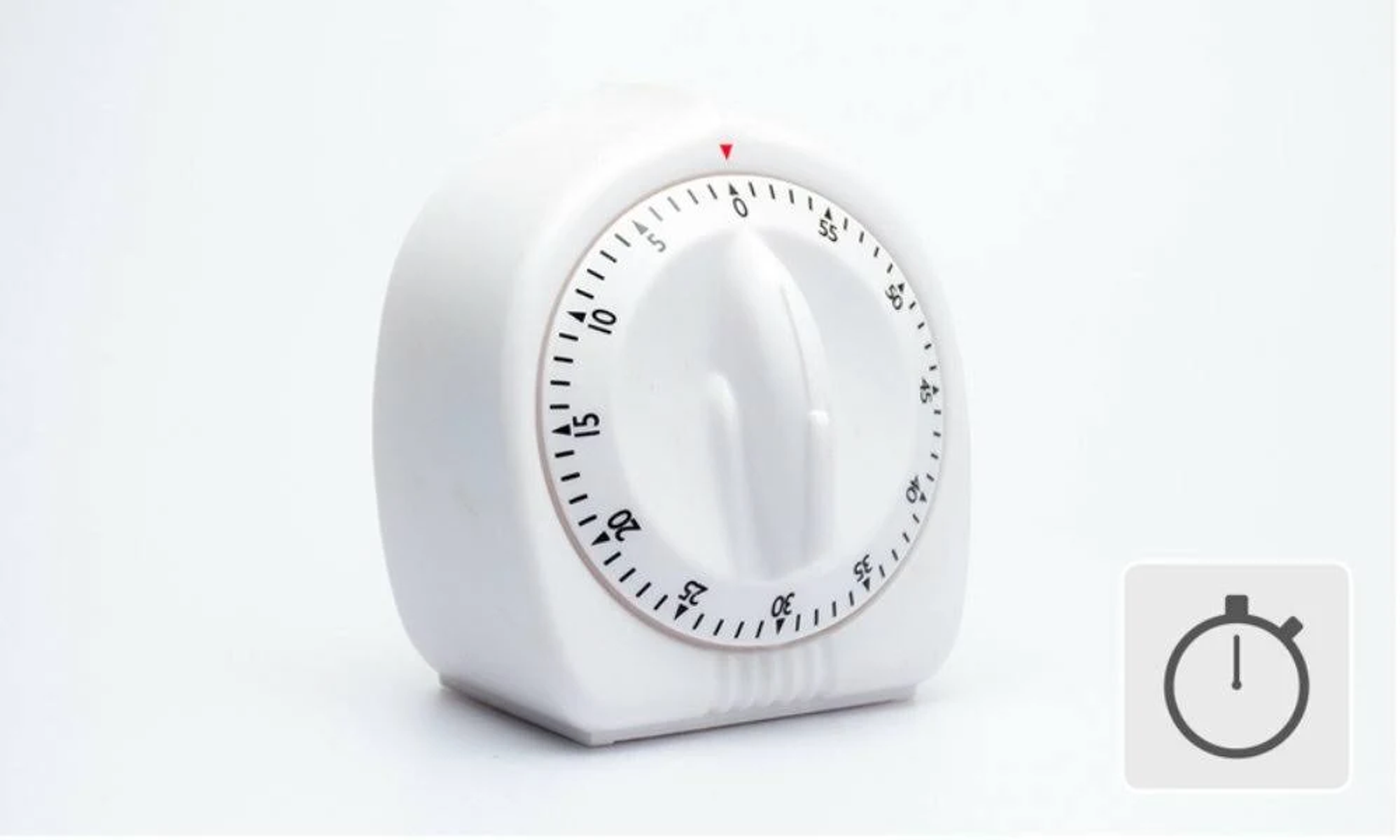 Biały minutnik kuchenny z tarczą, czarnymi oznaczeniami i czerwonym wskaźnikiem.