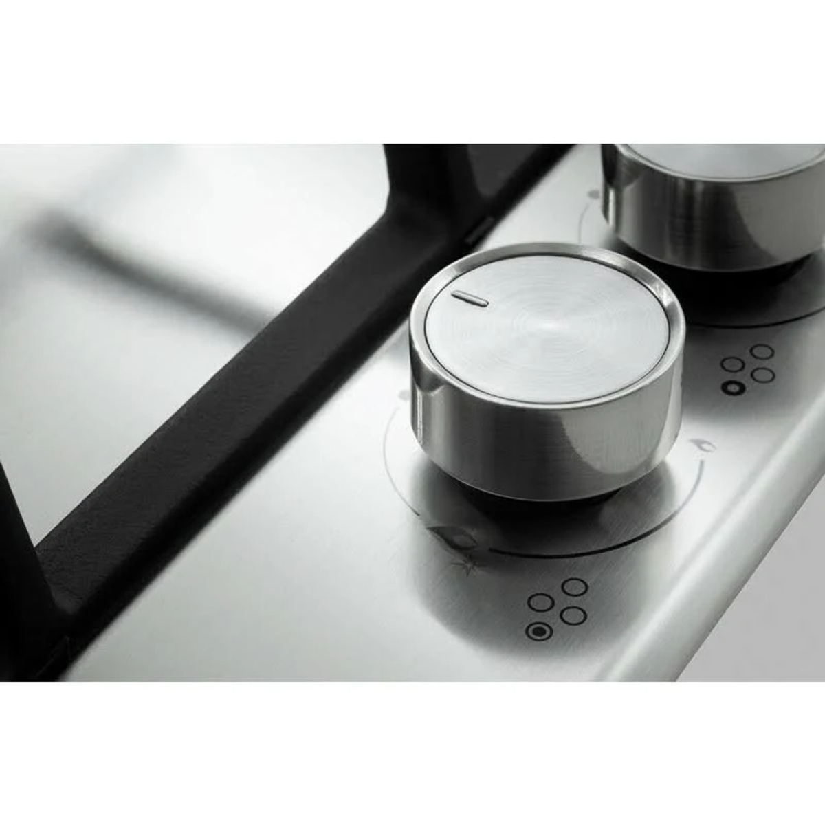 Zbliżenie na srebrne pokrętło sterowania płytą grzejną.