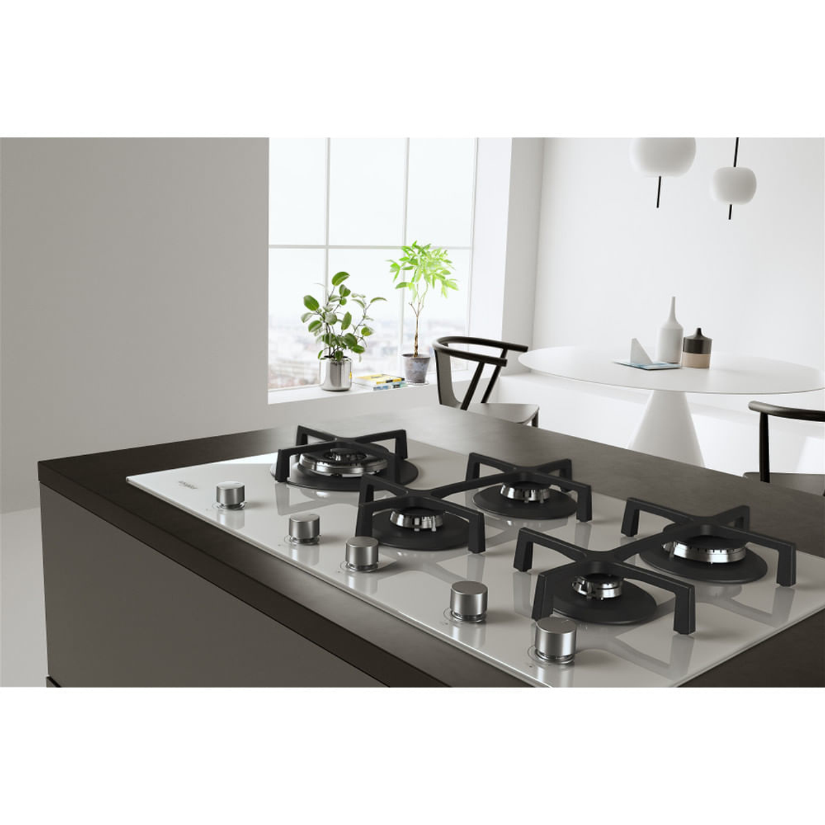 Biała płyta grzejna z czterema palnikami, zainstalowana w kuchni. W tle okno i stół jadalny.