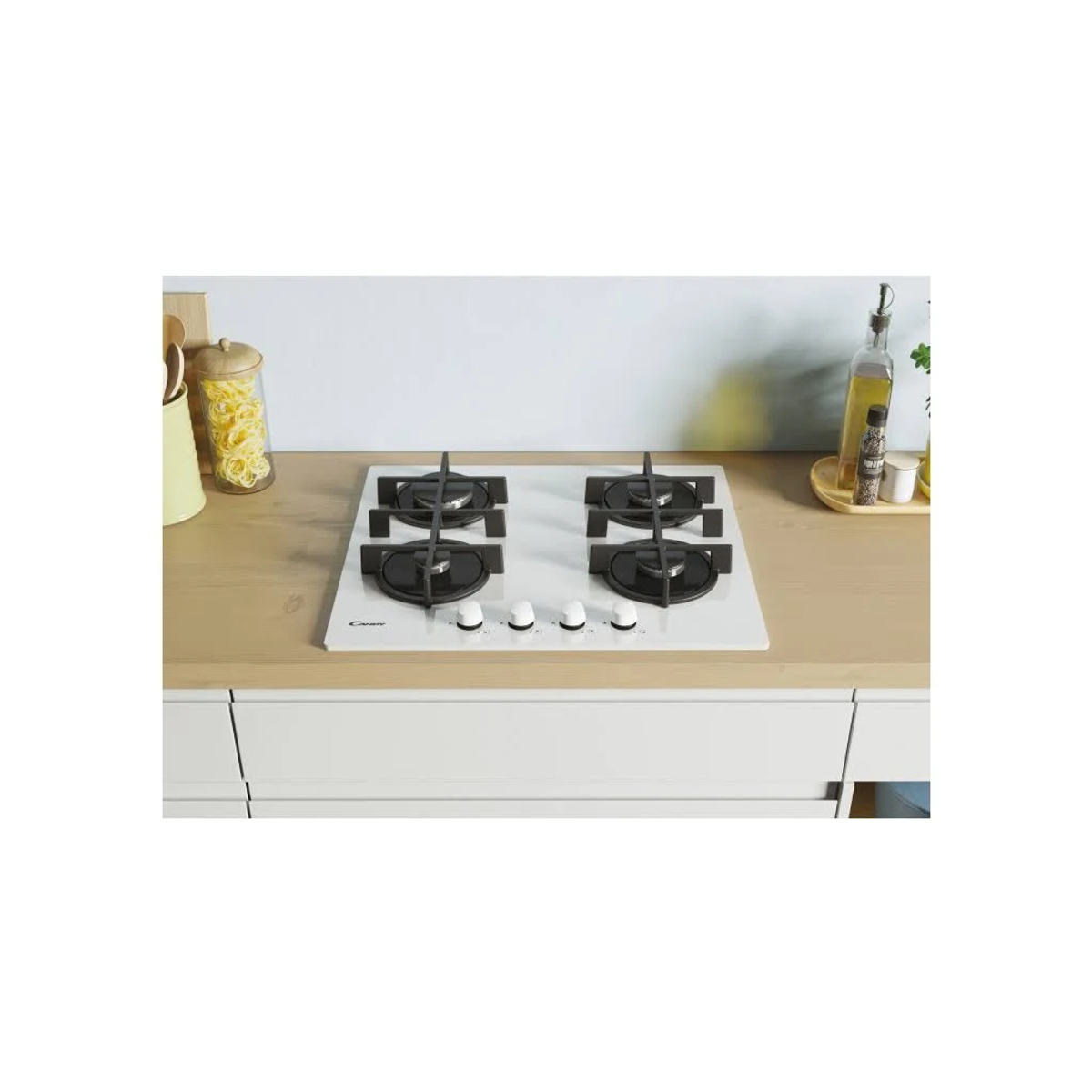 Biała płyta gazowa z czterema palnikami, czarnymi kratkami i srebrnymi pokrętłami na drewnianym blacie.