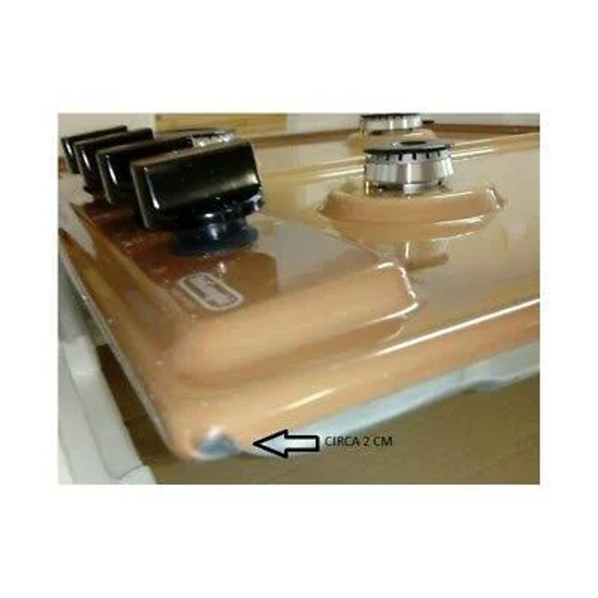 Płyta gazowa z czterema palnikami i pokrętłami. Płyta ma lekko zakrzywioną krawędź.