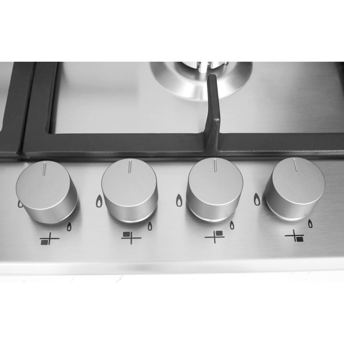 Zbliżenie srebrnych pokręteł palników na powierzchni płyty kuchennej ze stali nierdzewnej.