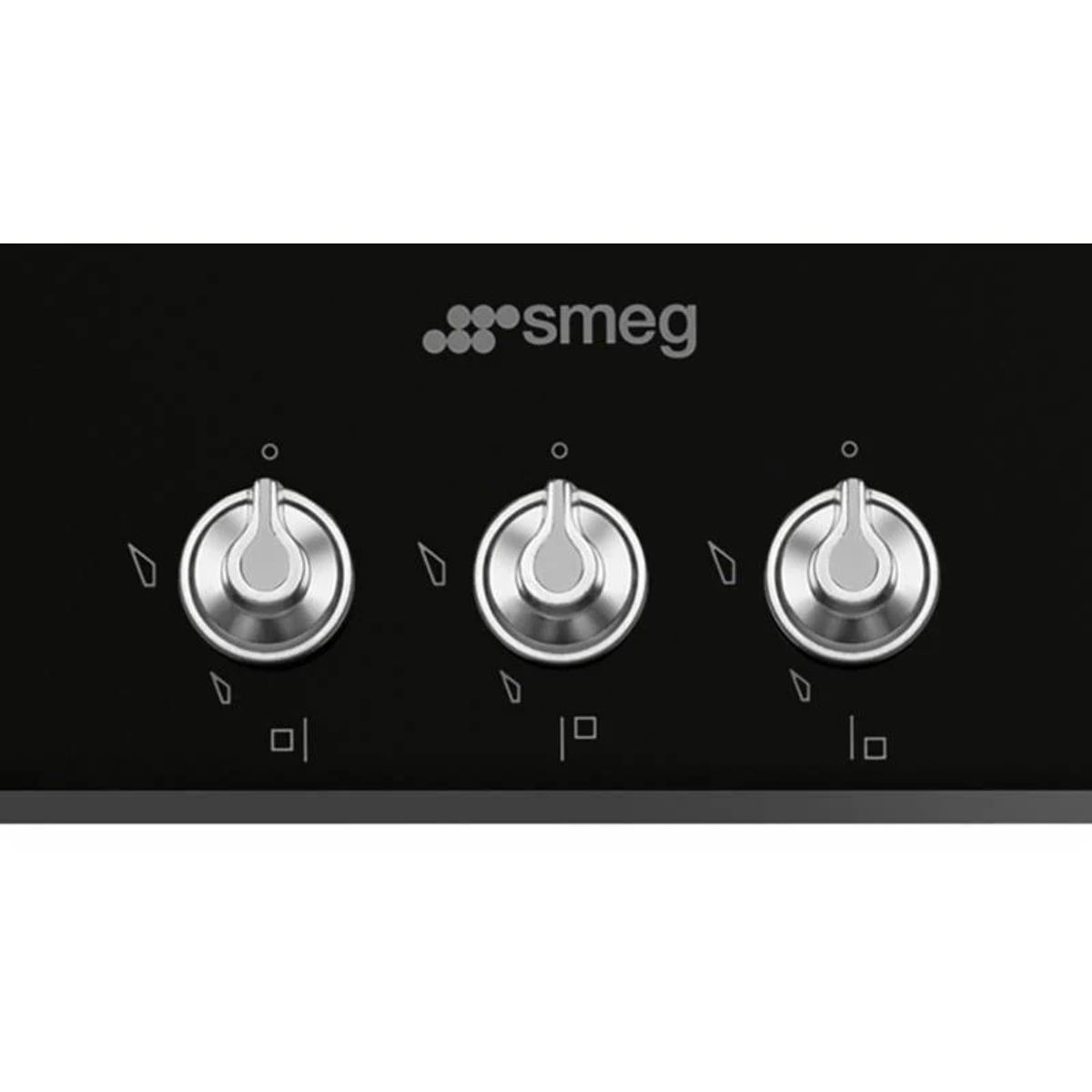 Primer plano de los mandos de la placa de gas Smeg, plateados y negros, tres en fila.