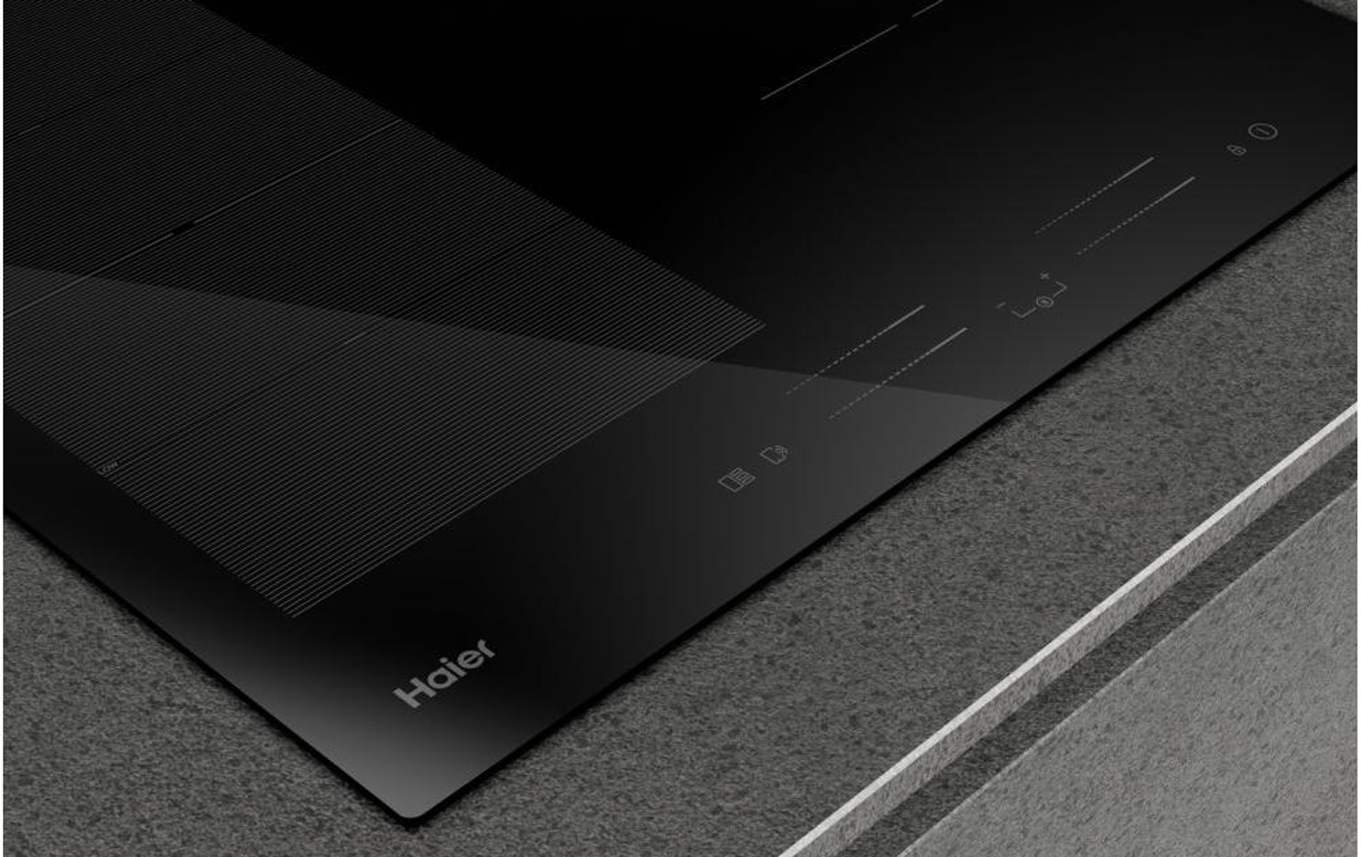 Zbliżenie czarnej płyty grzewczej z marką Haier. Widoczne elementy sterowania dotykowego i strefy gotowania.