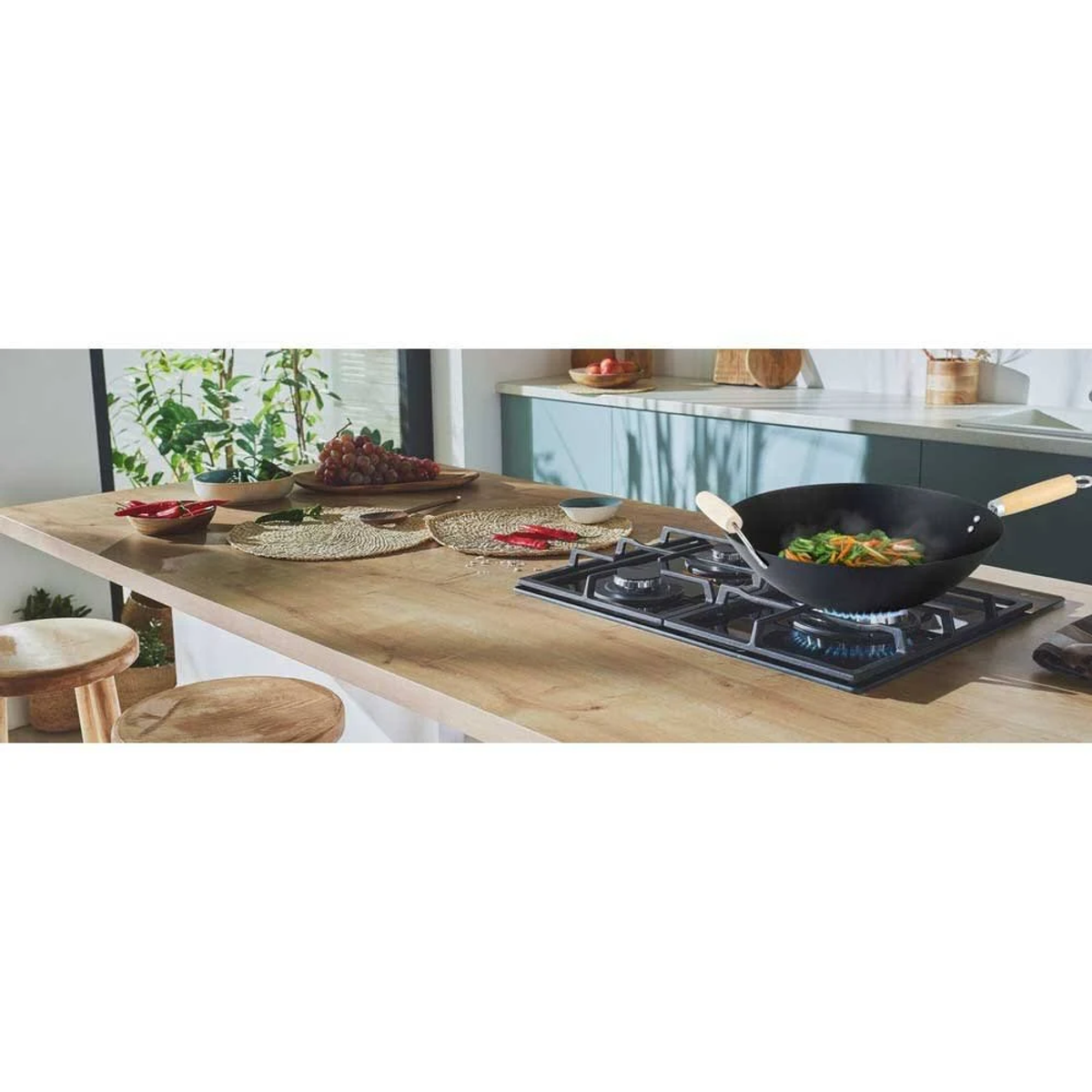 Un wok con comida en una estufa de gas sobre una encimera de madera, con artículos de cocina.