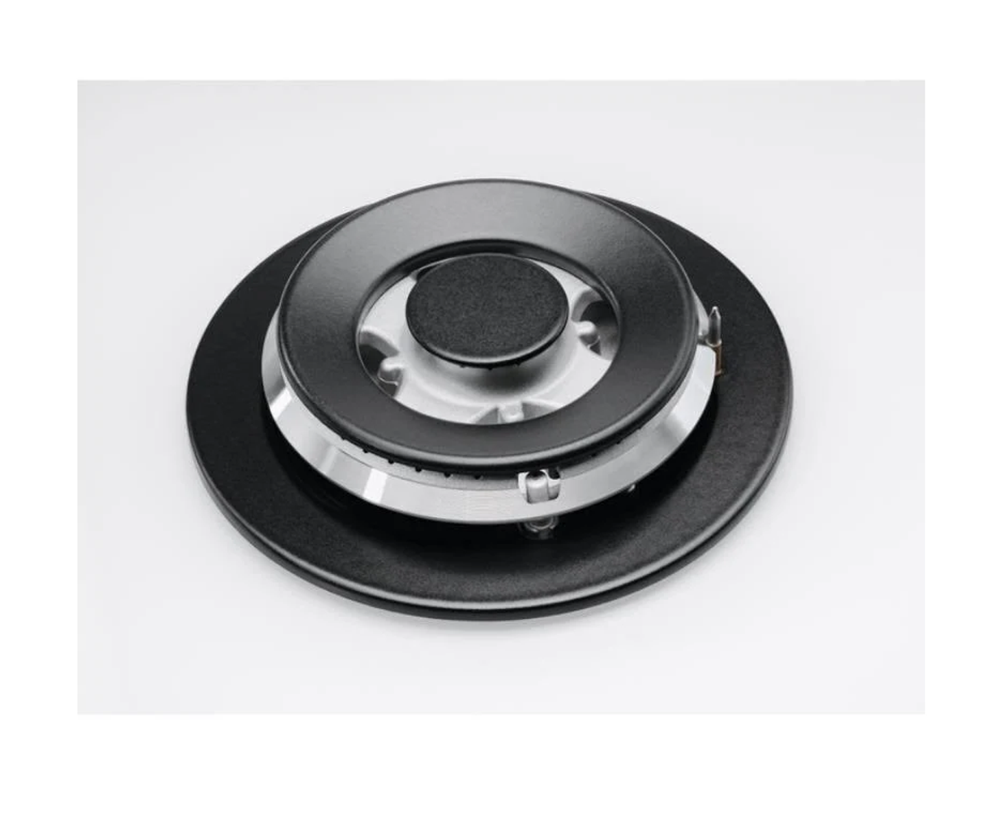 Zbliżenie czarnego zespołu palnika na białej powierzchni. Czarny i srebrny.