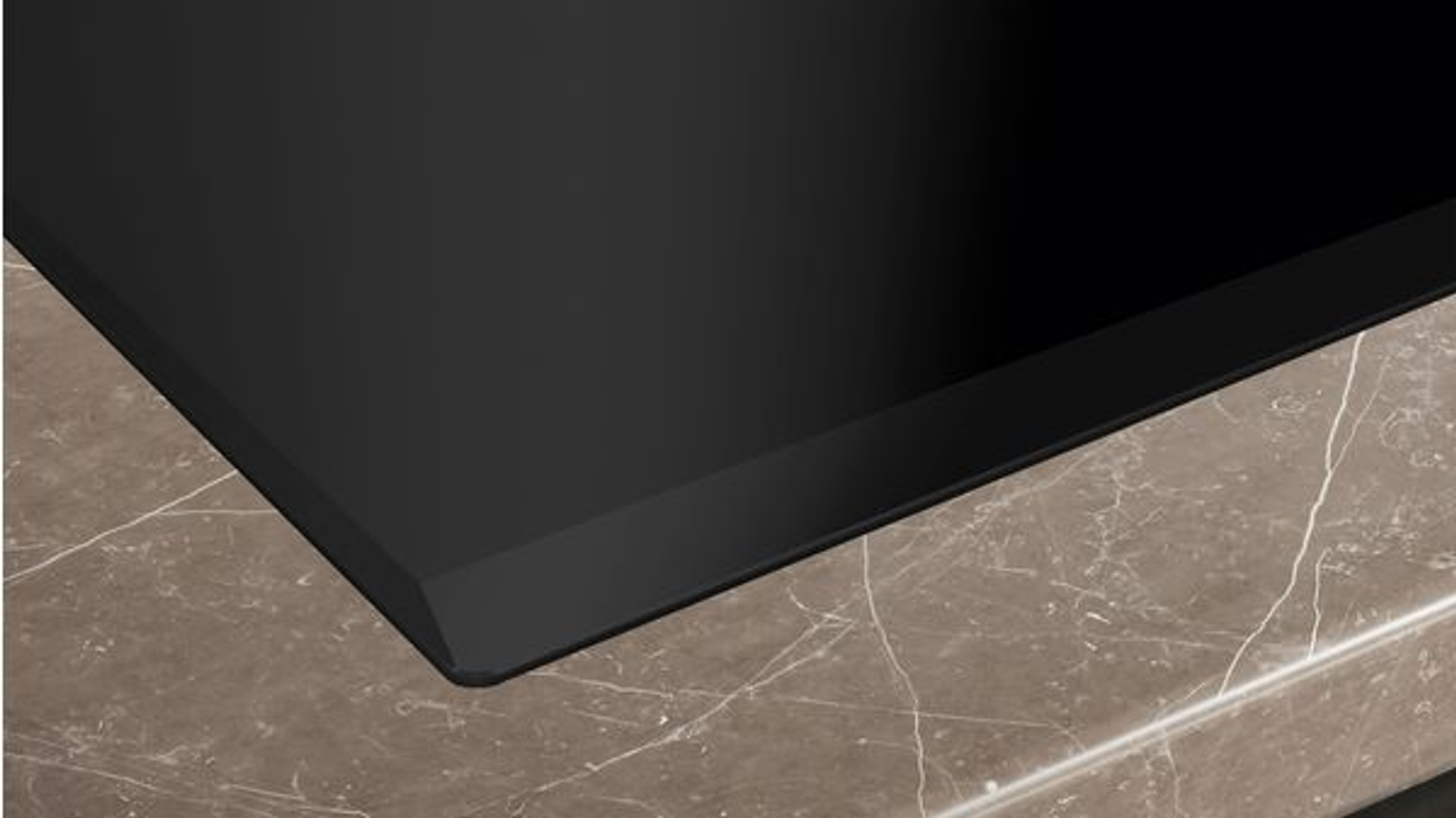 Zbliżenie krawędzi czarnego blatu z ciemną powierzchnią na górze.