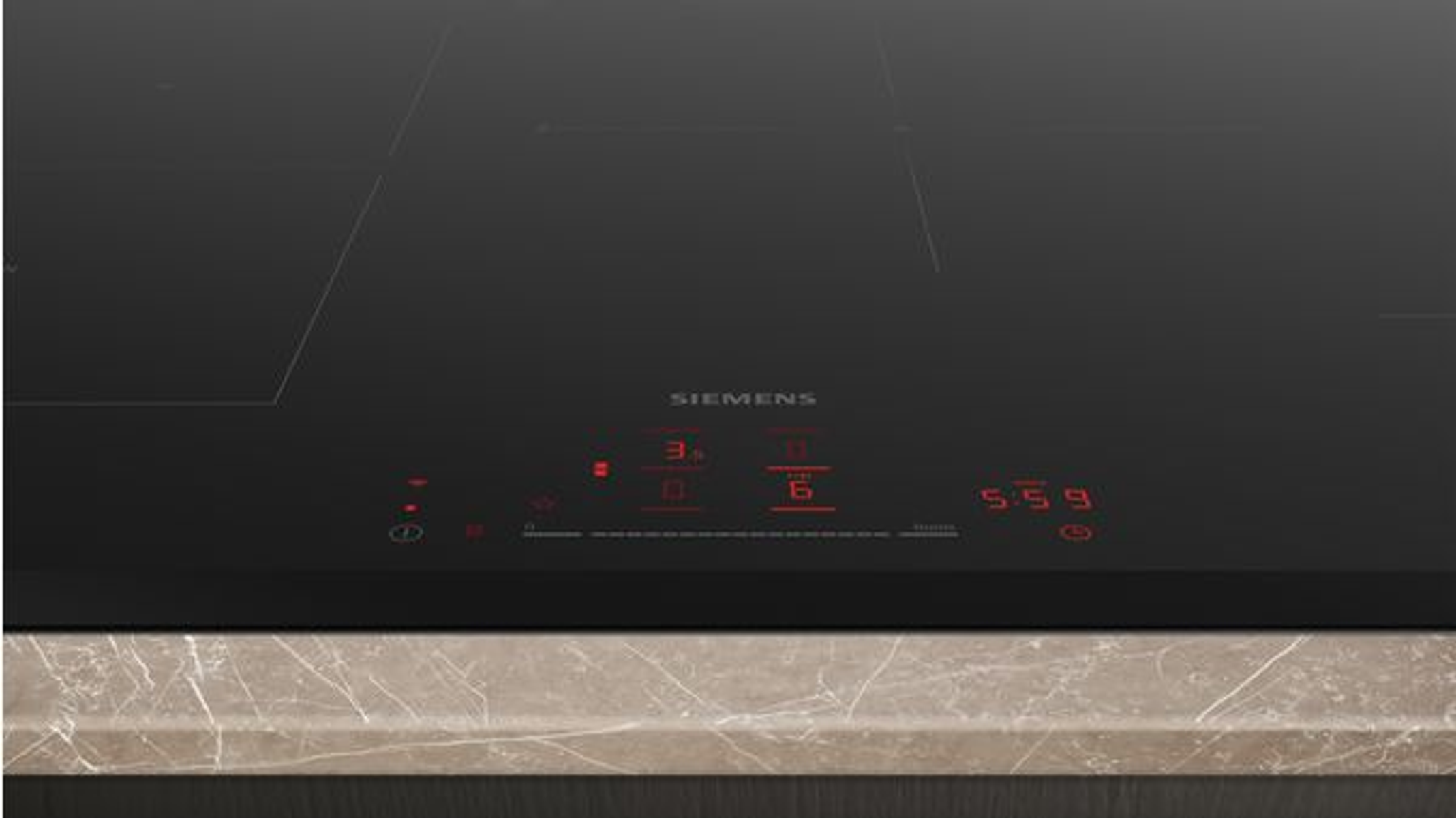 Piano cottura nero con display rosso che mostra numeri. Piano di lavoro in marmo.