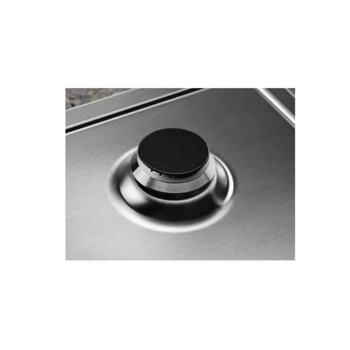 Zbliżenie palnika kuchenki gazowej. Ma czarne centrum i srebrną metalową podstawę.