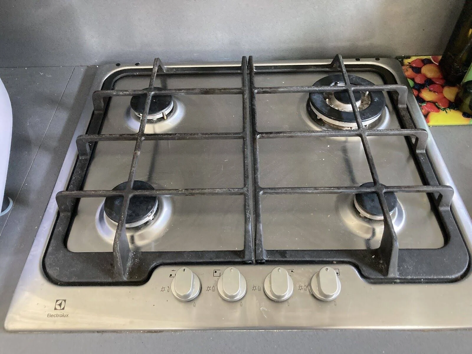 Płyta gazowa ze stali nierdzewnej z czterema palnikami i pokrętłami, marki Electrolux.