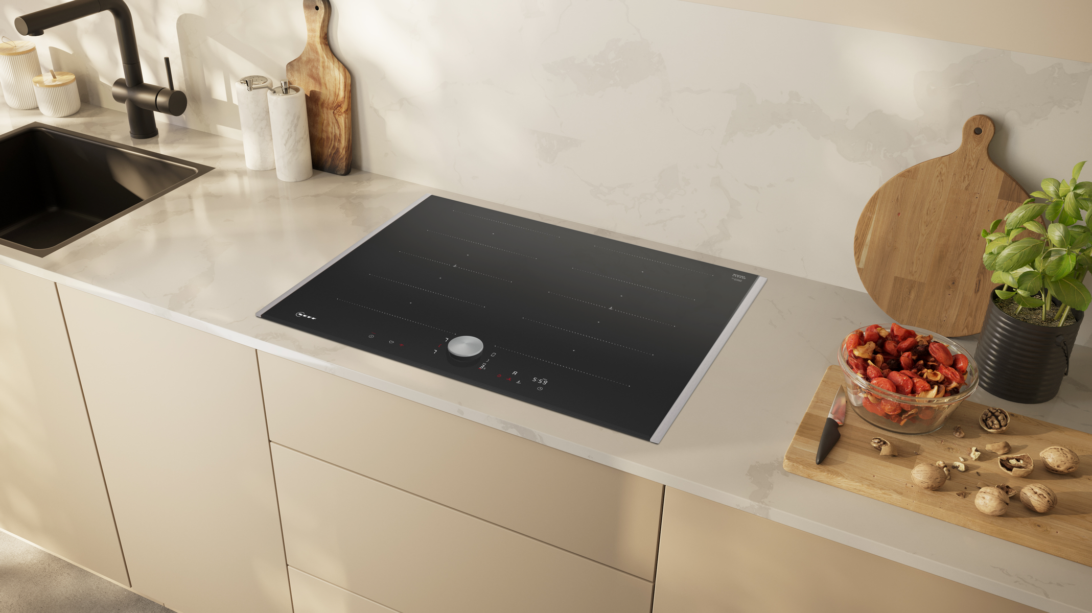 Piano cucina con piano cottura nero integrato. Taglieri e ciotole visibili.