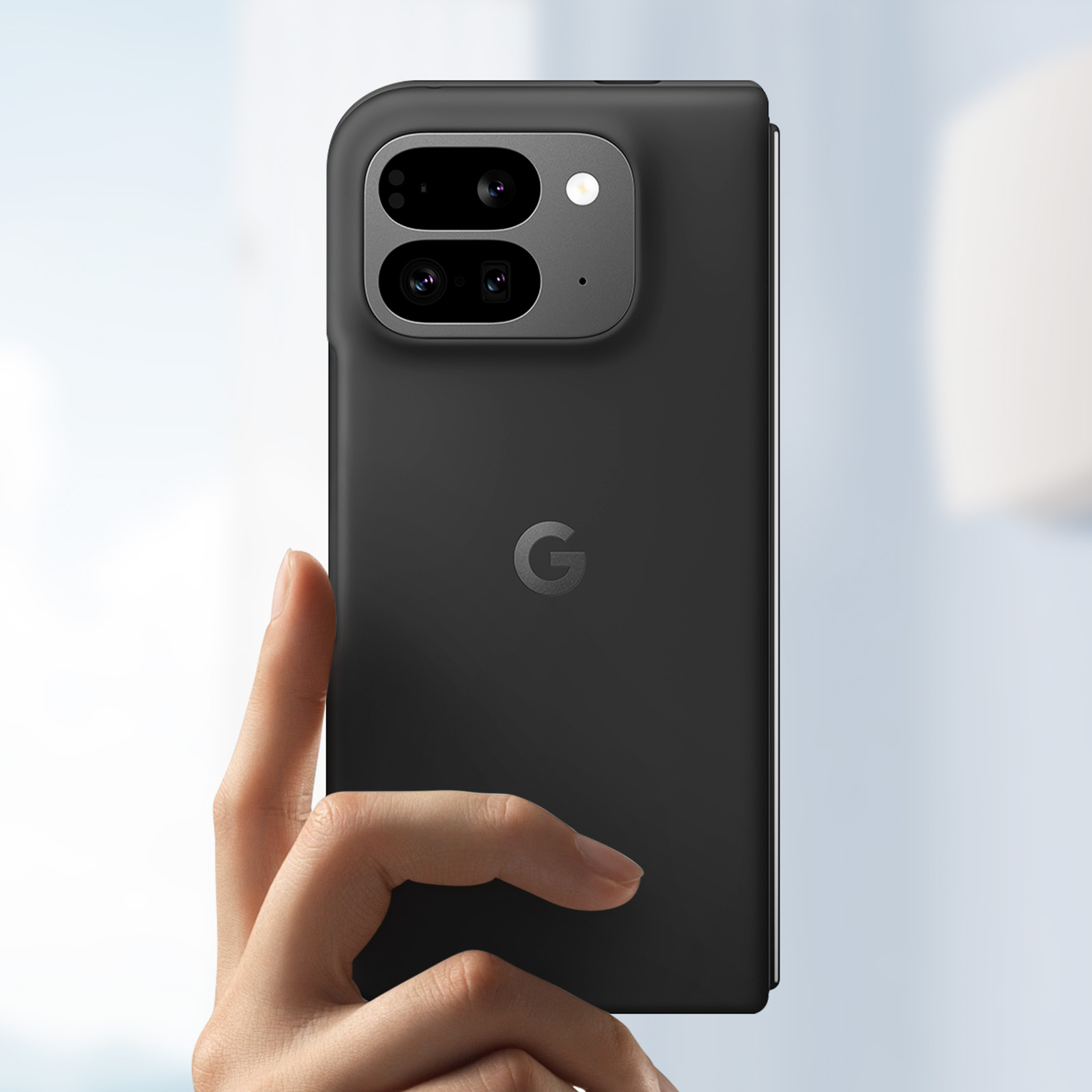 Ein schwarzes Smartphone in der Hand. Es hat eine Kameraerhebung und ein Google 'G'-Logo.