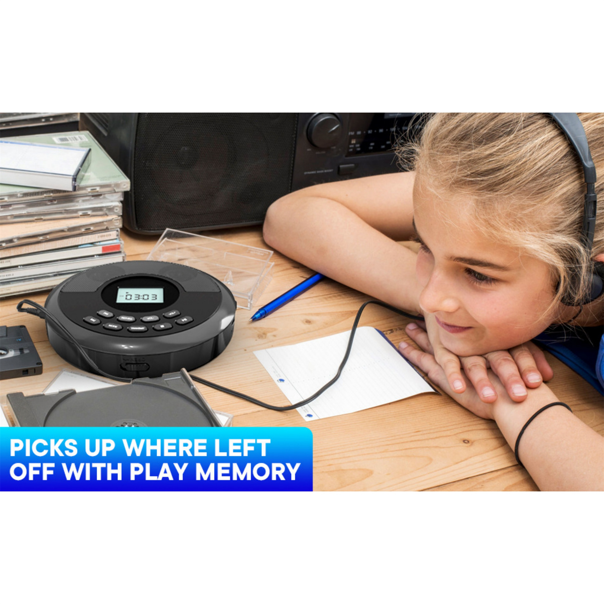 Mädchen mit Kopfhörern, betrachtet einen CD-Player mit CDs und einer Kassette auf Holzoberfläche.