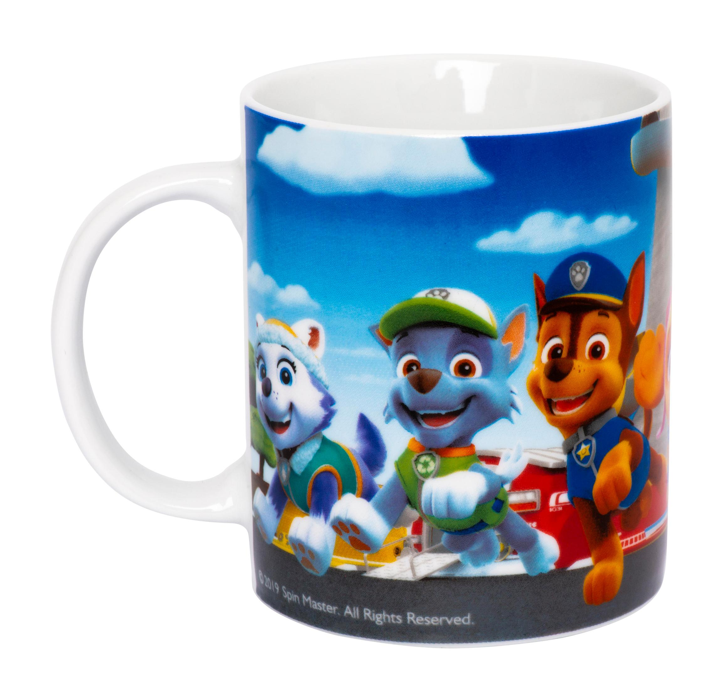 Weiße Tasse mit Paw Patrol-Charakteren: Chase, Skye und Marshall. Himmel und Wolken als Hintergrund.