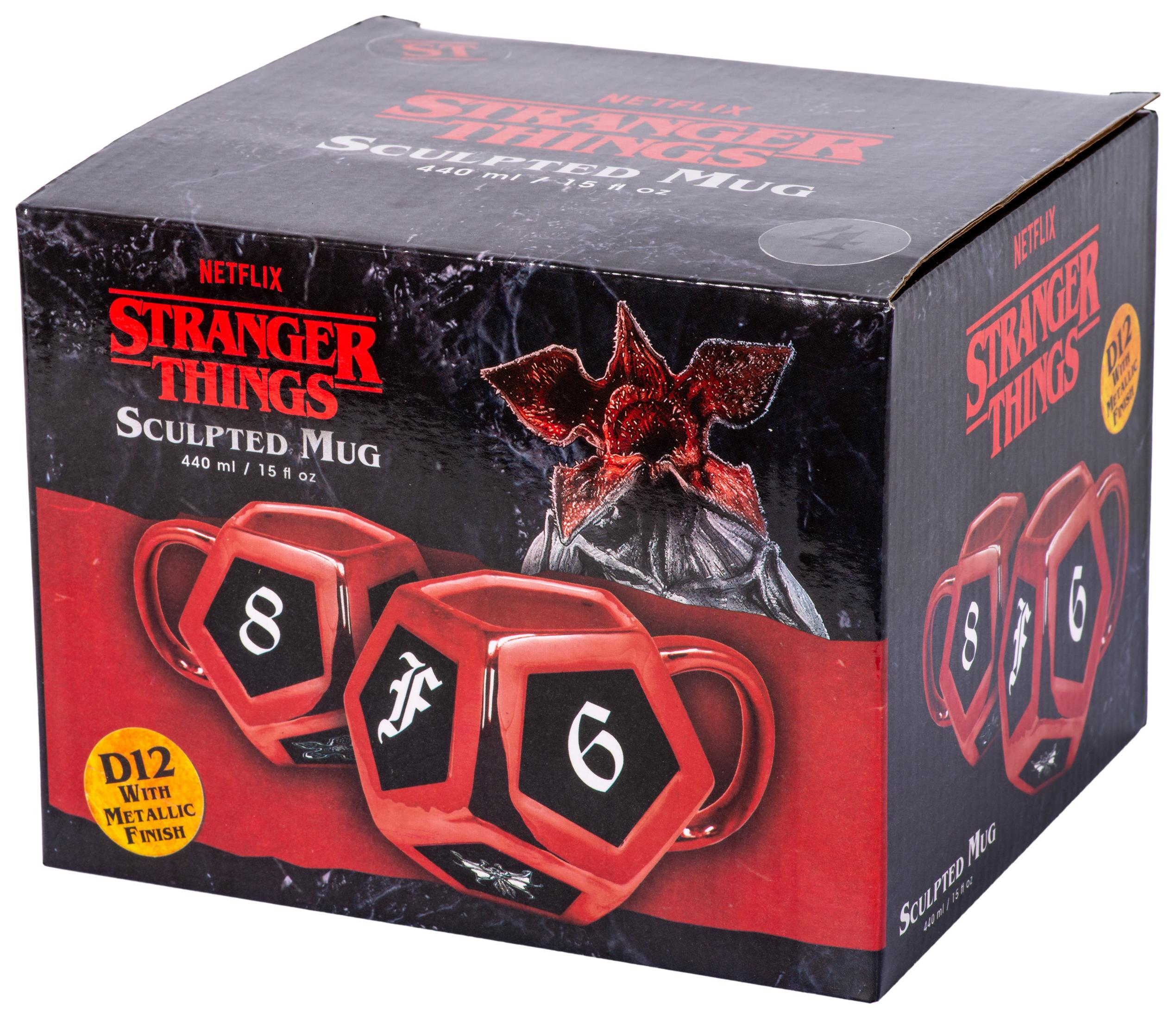 Karton mit Stranger Things-Tassen. Tassen sind rot mit schwarzen Würfelflächen. Demogorgon-Bild oben.
