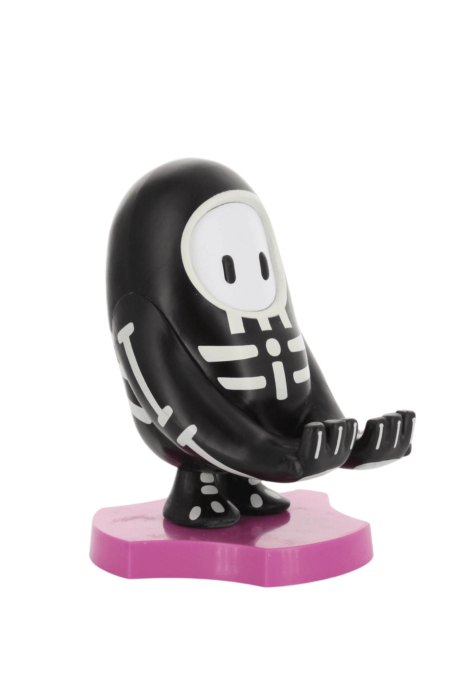 Statuetta scheletro del personaggio di Fall Guys su base rosa. Scheletro bianco e nero, su un supporto rosa.