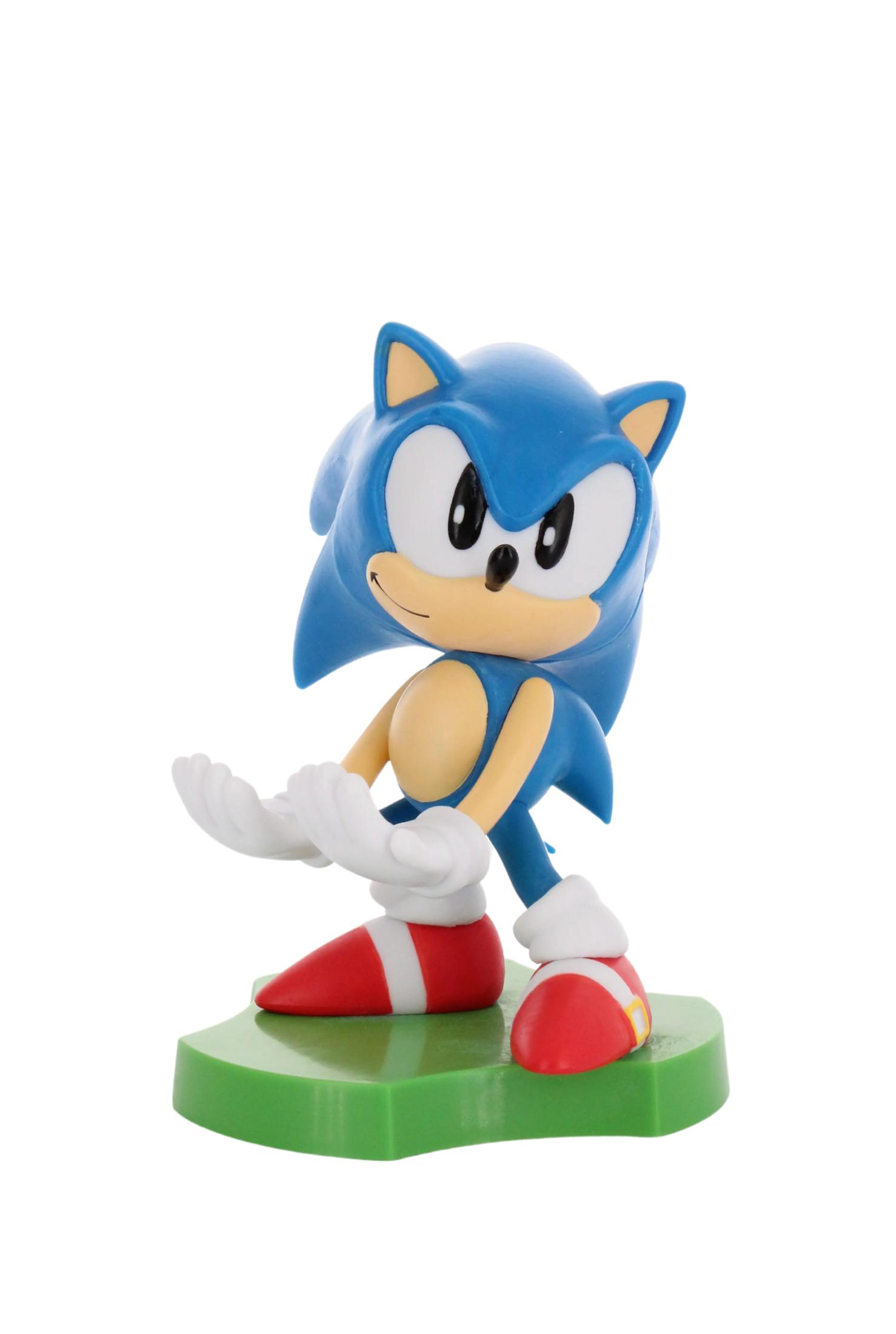 Statua blu di Sonic su base verde, braccia in su, guanti bianchi, scarpe rosse.