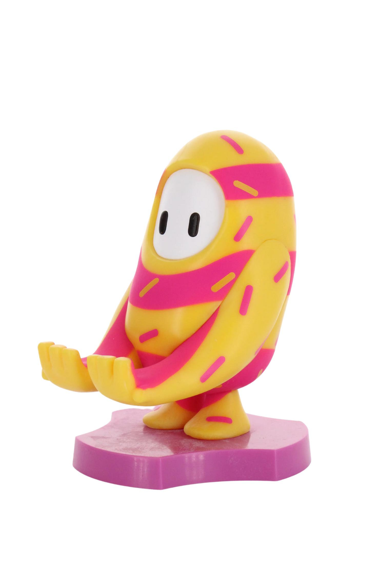 Un giocattolo del personaggio Fall Guys giallo e rosa su una base rosa, sfondo bianco.
