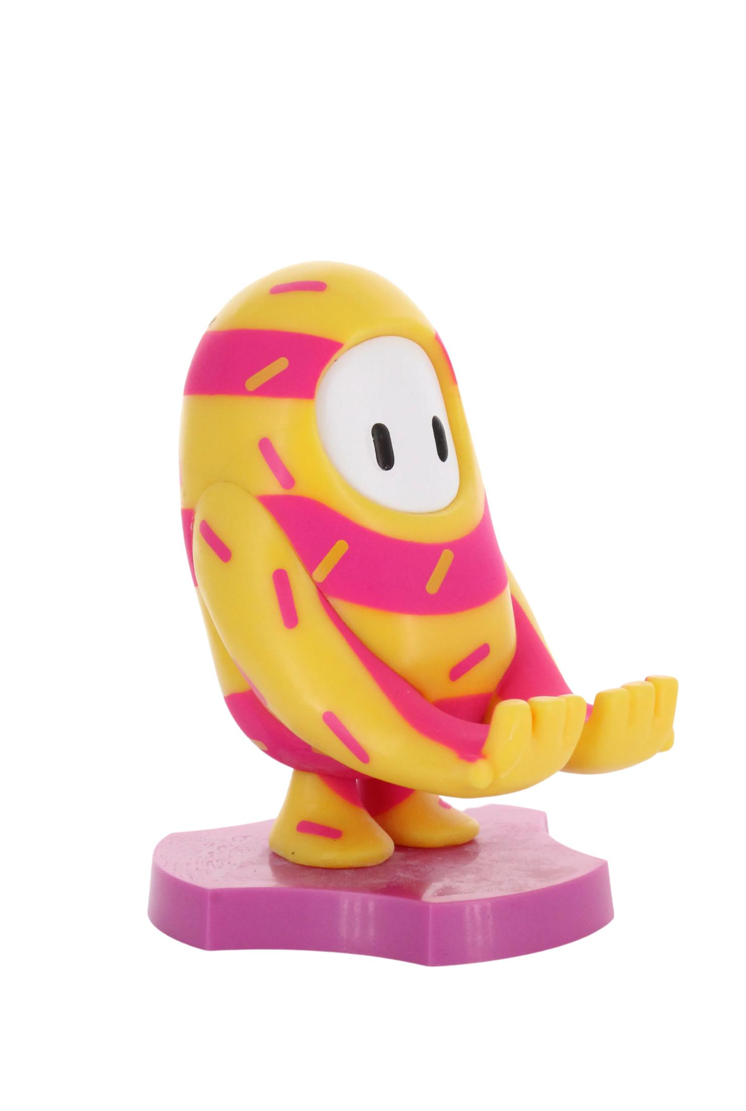 Una statuetta del personaggio di Fall Guys in costume da ciambella rosa e giallo, con le mani alzate.